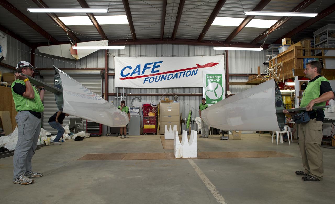 Team members of Pipistrel-USA prepare to have their Taurus G4 aircraft wings weighed using a scale built into the floor of the hangar during the 2011 Green Flight Challenge, sponsored by Google, at the Charles M. Schulz Sonoma County Airport in Santa Rosa, Calif. on Monday, Sept. 26, 2011. NASA and the Comparative Aircraft Flight Efficiency (CAFE) Foundation are having the challenge with the goal to advance technologies in fuel efficiency and reduced emissions with cleaner renewable fuels and electric aircraft. Photo Credit: (NASA/Bill Ingalls)