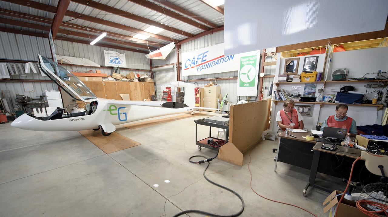 CAFE Foundation Weights crew member Ron Stout, left, and Weights Chief Wayne Cook, weigh-in the e-Genius aircraft during the 2011 Green Flight Challenge, sponsored by Google, at the Charles M. Schulz Sonoma County Airport in Santa Rosa, Calif. on Monday, Sept. 26, 2011.  NASA and the Comparative Aircraft Flight Efficiency (CAFE) Foundation are having the challenge with the goal to advance technologies in fuel efficiency and reduced emissions with cleaner renewable fuels and electric aircraft. Photo Credit: (NASA/Bill Ingalls)
