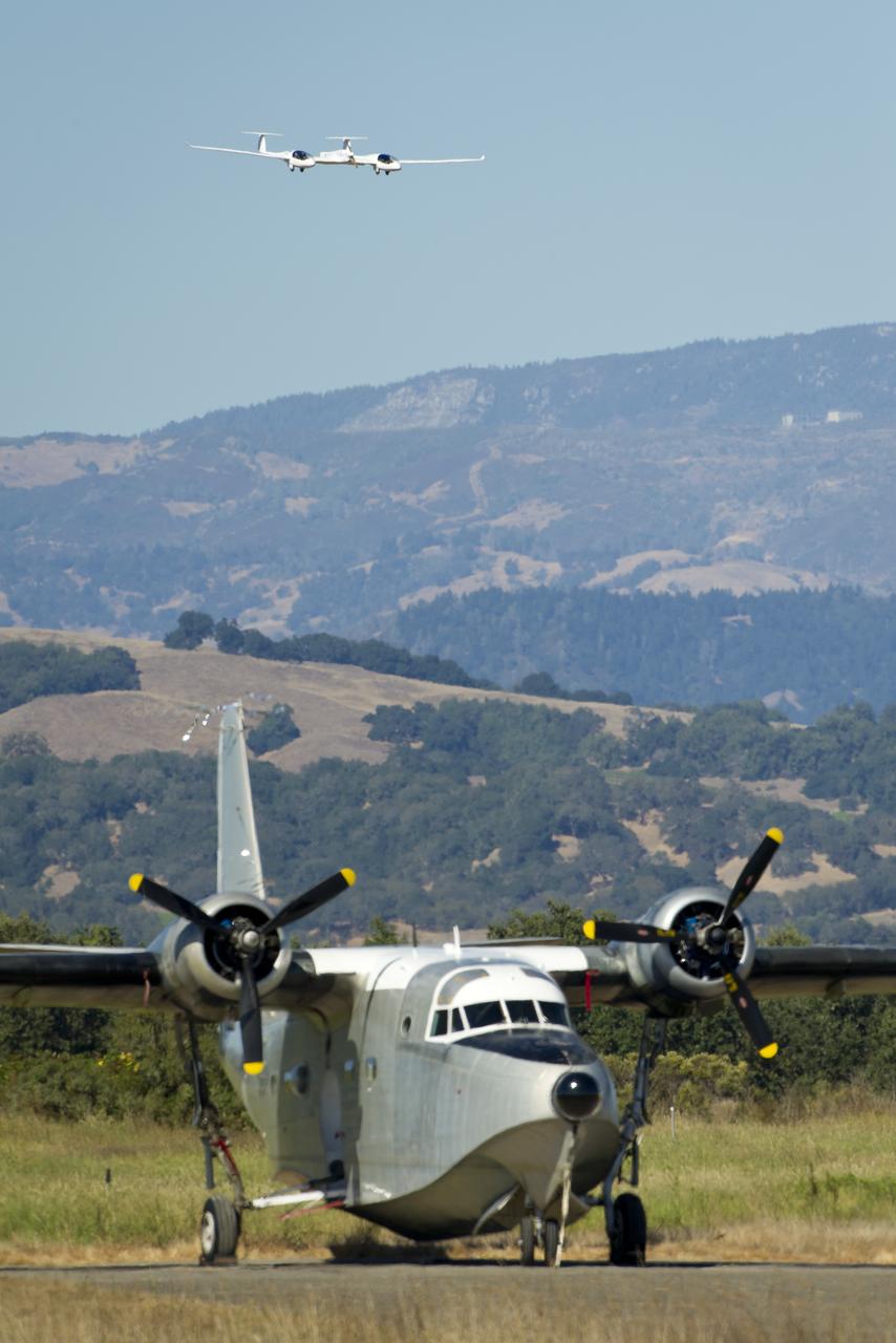 The Pipistrel-USA, Taurus G4 aircraft approaches for landing as a Grumman Albatross plane is seen in the forground during the 2011 Green Flight Challenge, sponsored by Google, at the Charles M. Schulz Sonoma County Airport in Santa Rosa, Calif. on Monday, Sept. 26, 2011. NASA and the Comparative Aircraft Flight Efficiency (CAFE) Foundation are having the challenge with the goal to advance technologies in fuel efficiency and reduced emissions with cleaner renewable fuels and electric aircraft. Photo Credit: (NASA/Bill Ingalls)