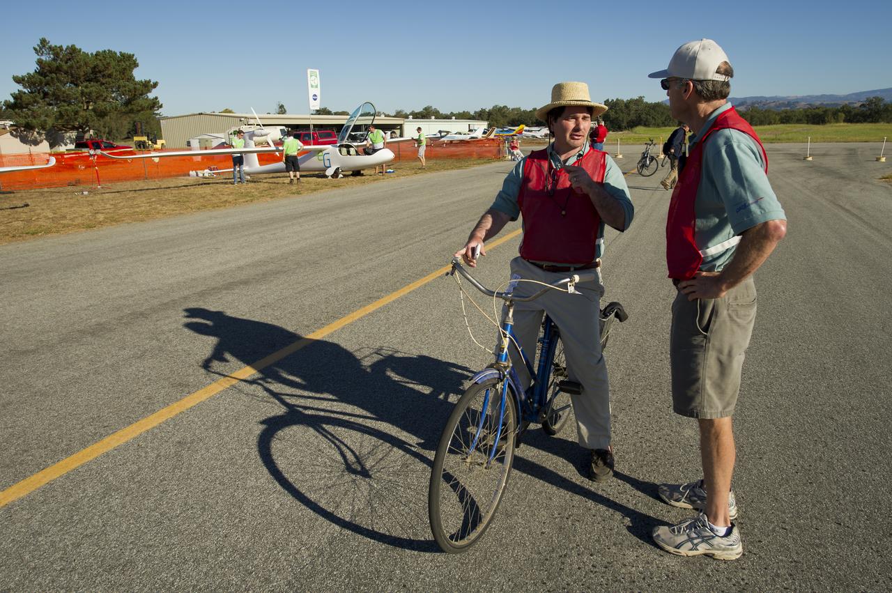 CAFE Foundation Security Chief and Event Manager Bruno Mombrinie, left, talks with CAFE Foundation eCharging Chief Alan Soule as flight crews prepare for the miles per gallon (MPG) flight during the 2011 Green Flight Challenge, sponsored by Google, at the Charles M. Schulz Sonoma County Airport in Santa Rosa, Calif. on Tuesday, Sept. 27, 2011. NASA and the Comparative Aircraft Flight Efficiency (CAFE) Foundation are having the challenge with the goal to advance technologies in fuel efficiency and reduced emissions with cleaner renewable fuels and electric aircraft. Photo Credit: (NASA/Bill Ingalls)