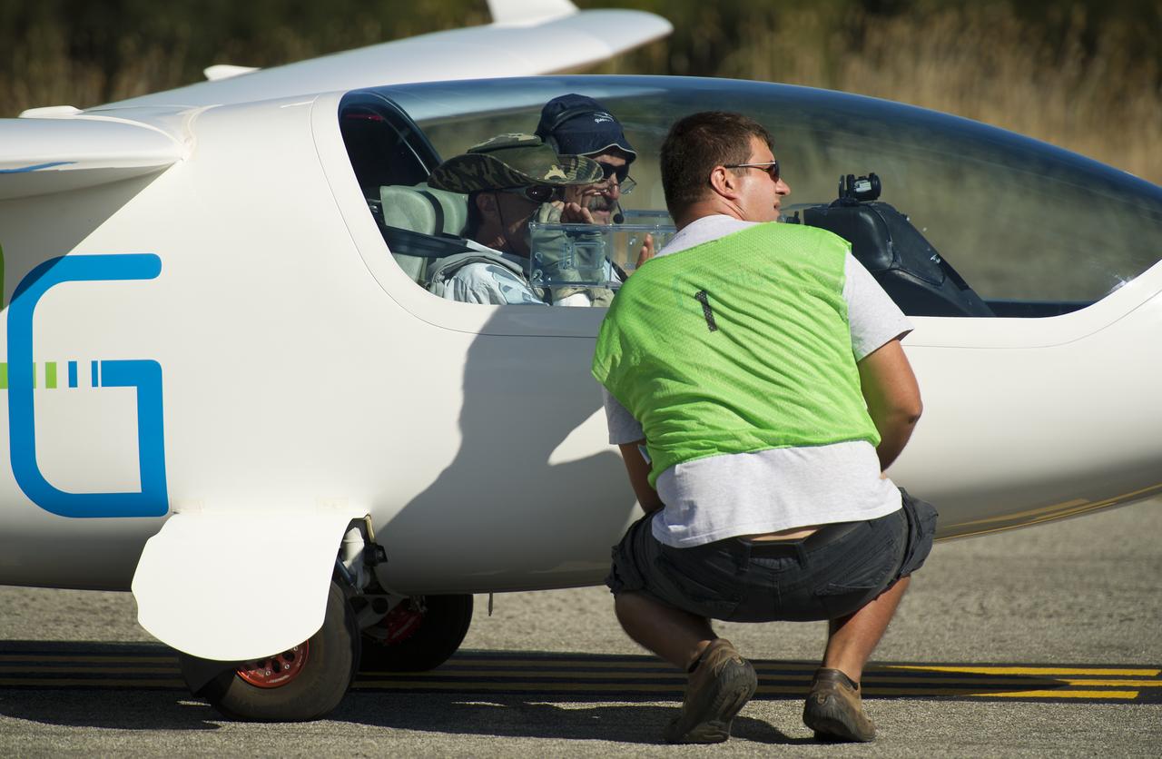 The e-Genius pilots talk with a fellow team member prior to their takeoff for the miles per gallon (MPG) flight during the 2011 Green Flight Challenge, sponsored by Google, at the Charles M. Schulz Sonoma County Airport in Santa Rosa, Calif. on Tuesday, Sept. 27, 2011.  NASA and the Comparative Aircraft Flight Efficiency (CAFE) Foundation are having the challenge with the goal to advance technologies in fuel efficiency and reduced emissions with cleaner renewable fuels and electric aircraft. Photo Credit: (NASA/Bill Ingalls)