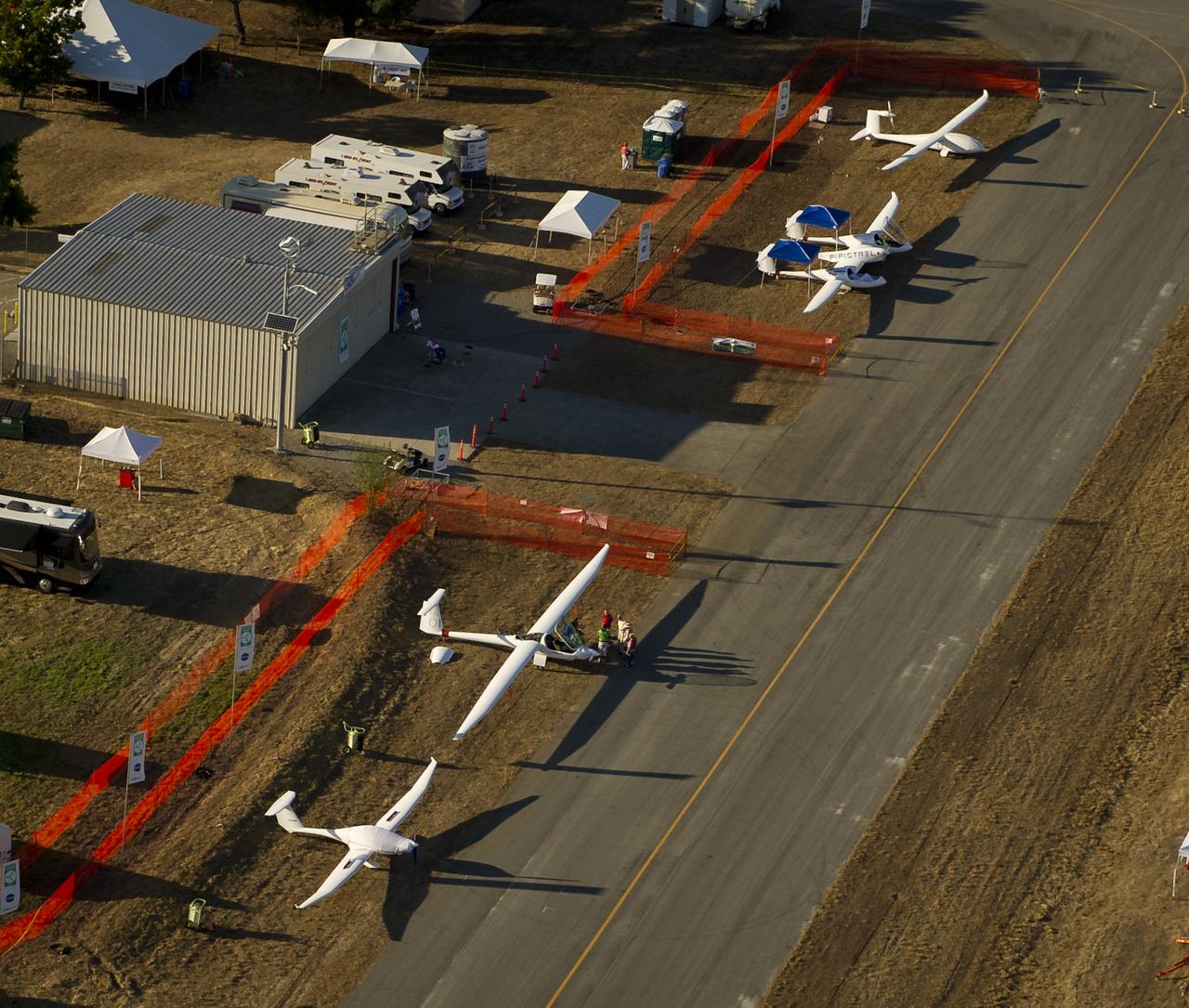 The PhoEnix, lower left, EcoEagle, 2nd from left, Taurus G4, and e-Genius aircraft, top right, are seen on the campus of the 2011 Green Flight Challenge, sponsored by Google, at the Charles M. Schulz Sonoma County Airport in Santa Rosa, Calif. on Wednesday, Sept. 28, 2011. NASA and the Comparative Aircraft Flight Efficiency (CAFE) Foundation are having the challenge with the goal to advance technologies in fuel efficiency and reduced emissions with cleaner renewable fuels and electric aircraft. Photo Credit: (NASA/Bill Ingalls)