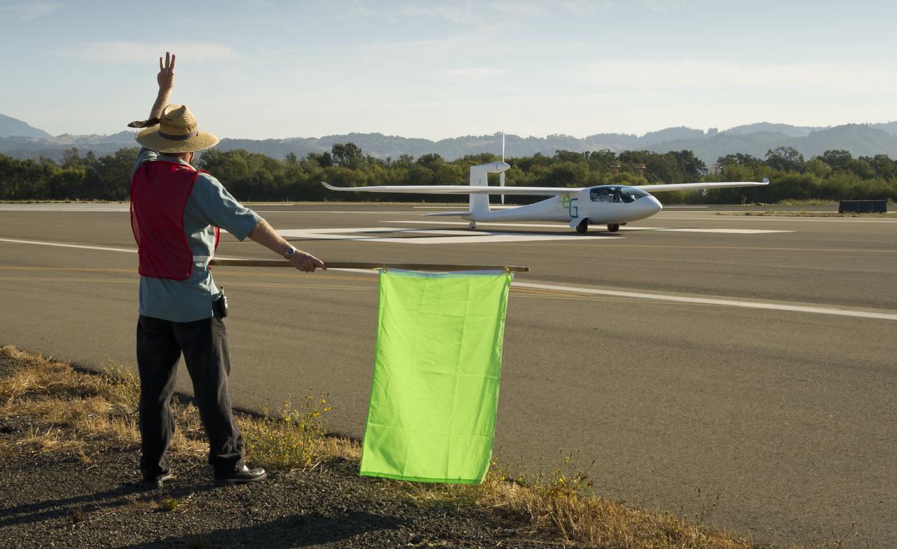 CAFE Foundation Hanger Boss Mike Fenn directs the e-Genius aircraft to the start of the speed competition during the 2011 Green Flight Challenge, sponsored by Google, at the Charles M. Schulz Sonoma County Airport in Santa Rosa, Calif. on Thursday, Sept. 29, 2011. NASA and the Comparative Aircraft Flight Efficiency (CAFE) Foundation are having the challenge with the goal to advance technologies in fuel efficiency and reduced emissions with cleaner renewable fuels and electric aircraft. Photo Credit: (NASA/Bill Ingalls)