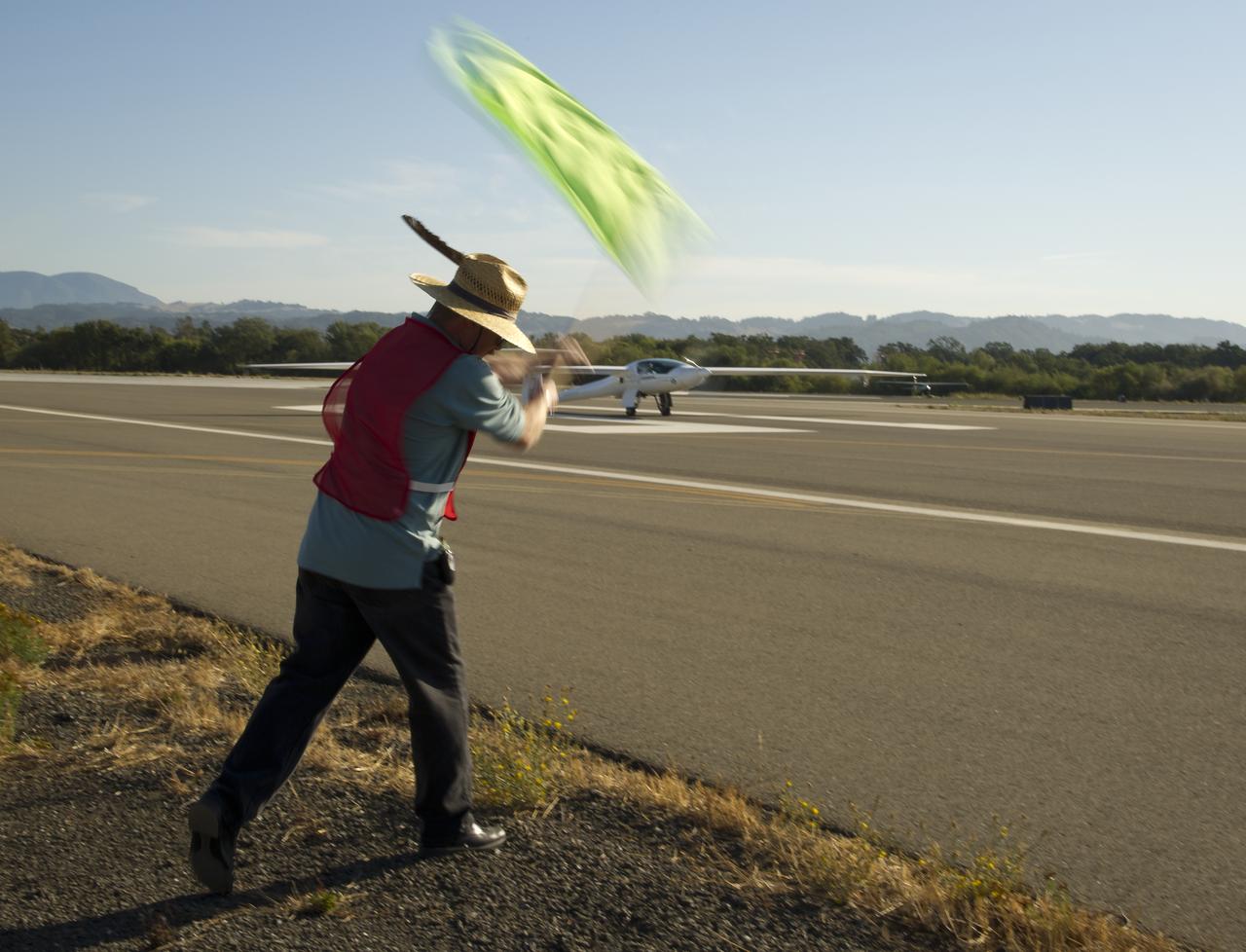 CAFE Foundation Hanger Boss Mike Fenn waves the speed competition start flag for the EcoEagle aircraft during the 2011 Green Flight Challenge, sponsored by Google, at the Charles M. Schulz Sonoma County Airport in Santa Rosa, Calif. on Thursday, Sept. 29, 2011. NASA and the Comparative Aircraft Flight Efficiency (CAFE) Foundation are having the challenge with the goal to advance technologies in fuel efficiency and reduced emissions with cleaner renewable fuels and electric aircraft. Photo Credit: (NASA/Bill Ingalls)