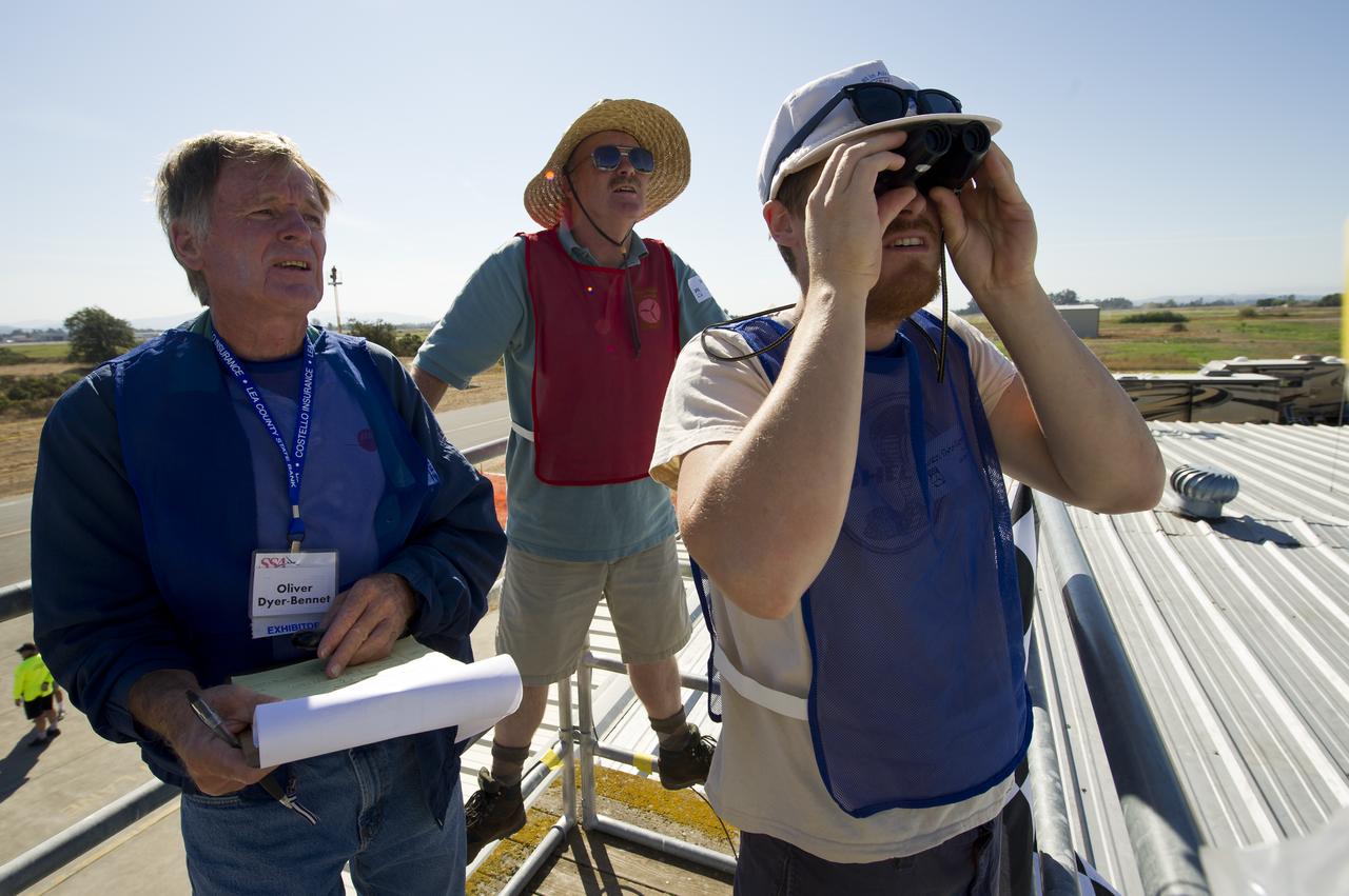 CAFE Foundation volunteer Oliver Dyer-Bennet, left, CAFE Foundation Hanger Boss Mike Fenn, center, and CAFE Foundation volunteer, Justin Dyer-Bennett scan the sky for aircraft during the speed competition portion of the 2011 Green Flight Challenge, sponsored by Google, being held at the Charles M. Schulz Sonoma County Airport in Santa Rosa, Calif. on Thursday, Sept. 29, 2011. NASA and the Comparative Aircraft Flight Efficiency (CAFE) Foundation are having the challenge with the goal to advance technologies in fuel efficiency and reduced emissions with cleaner renewable fuels and electric aircraft. Photo Credit: (NASA/Bill Ingalls)