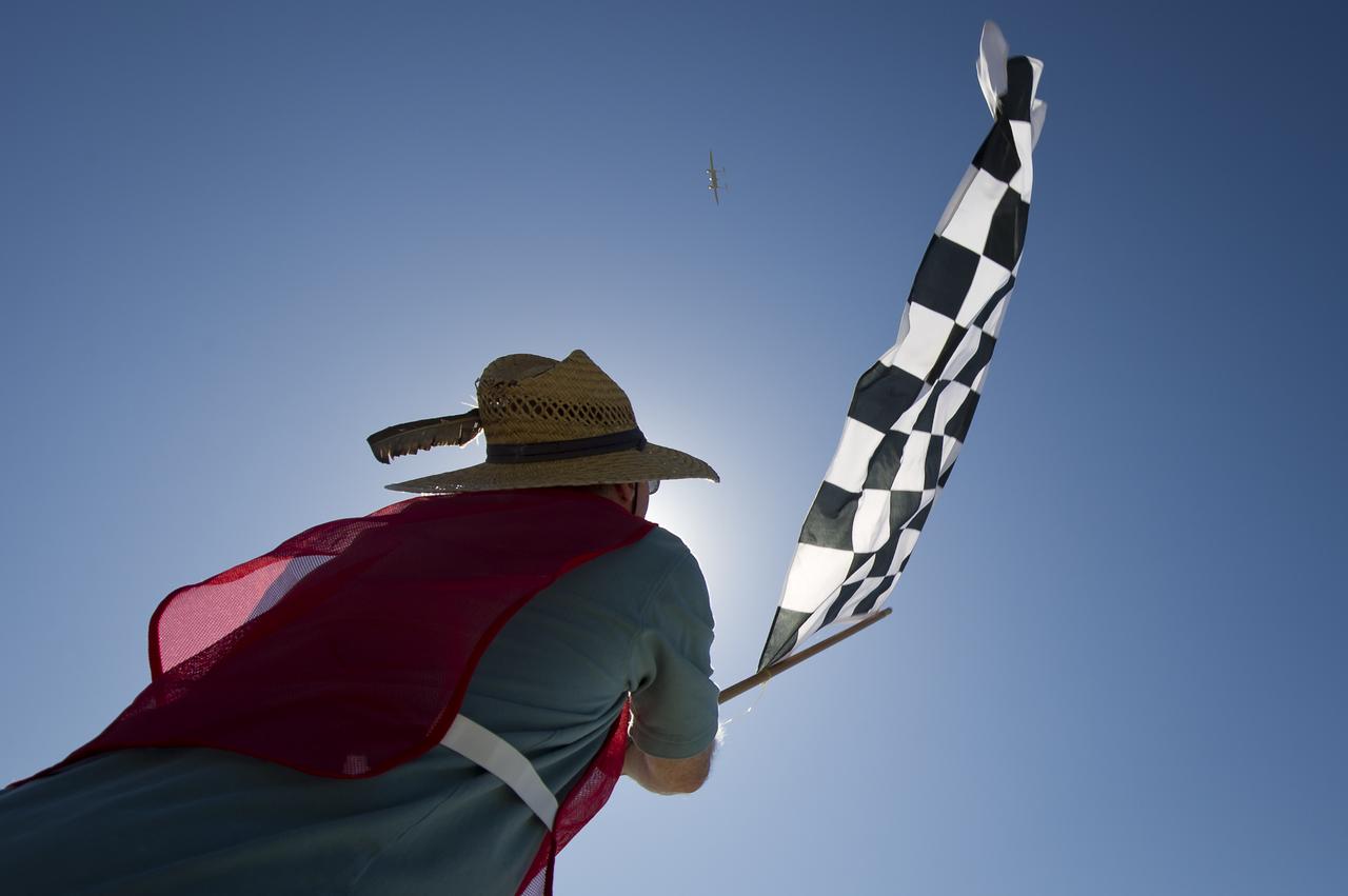 CAFE Foundation Hanger Boss Mike Fenn waves the speed competition checkered flag for the Taurus G4 aircraft during the 2011 Green Flight Challenge, sponsored by Google, at the Charles M. Schulz Sonoma County Airport in Santa Rosa, Calif. on Thursday, Sept. 29, 2011. NASA and the Comparative Aircraft Flight Efficiency (CAFE) Foundation are having the challenge with the goal to advance technologies in fuel efficiency and reduced emissions with cleaner renewable fuels and electric aircraft. Photo Credit: (NASA/Bill Ingalls)