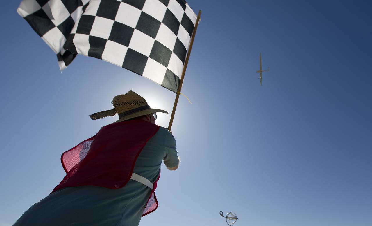CAFE Foundation Hanger Boss Mike Fenn waves the speed competition checkered flag for the EcoEagle aircraft during the 2011 Green Flight Challenge, sponsored by Google, at the Charles M. Schulz Sonoma County Airport in Santa Rosa, Calif. on Thursday, Sept. 29, 2011. NASA and the Comparative Aircraft Flight Efficiency (CAFE) Foundation are having the challenge with the goal to advance technologies in fuel efficiency and reduced emissions with cleaner renewable fuels and electric aircraft. Photo Credit: (NASA/Bill Ingalls)