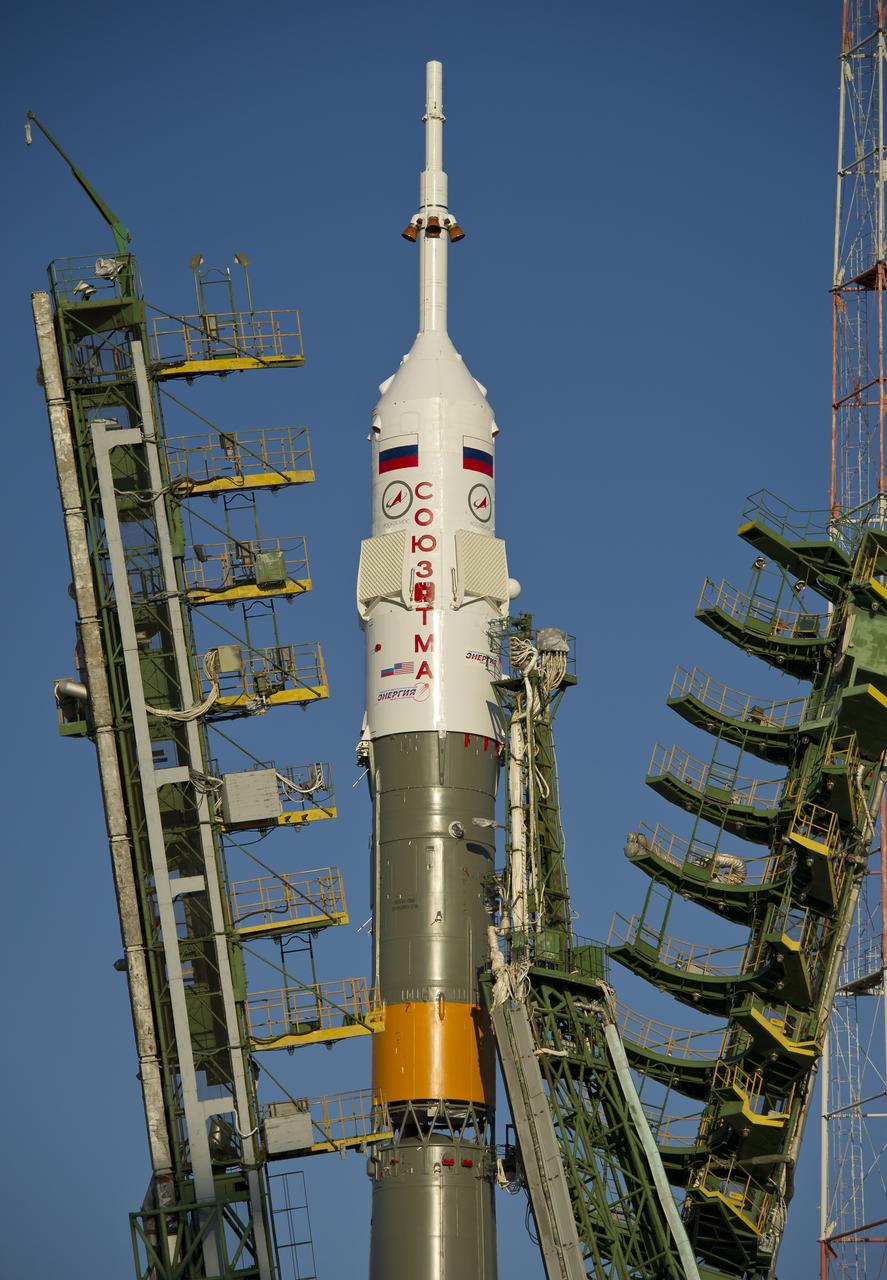 Large gantry mechanisms on either side of the Soyuz TMA-22 spacecraft are raised into position to secure the rocket at the launch pad on Friday, Nov. 11, 2011 at the Baikonur Cosmodrome in Kazakhstan.  Photo Credit:  (NASA/Carla Cioffi)