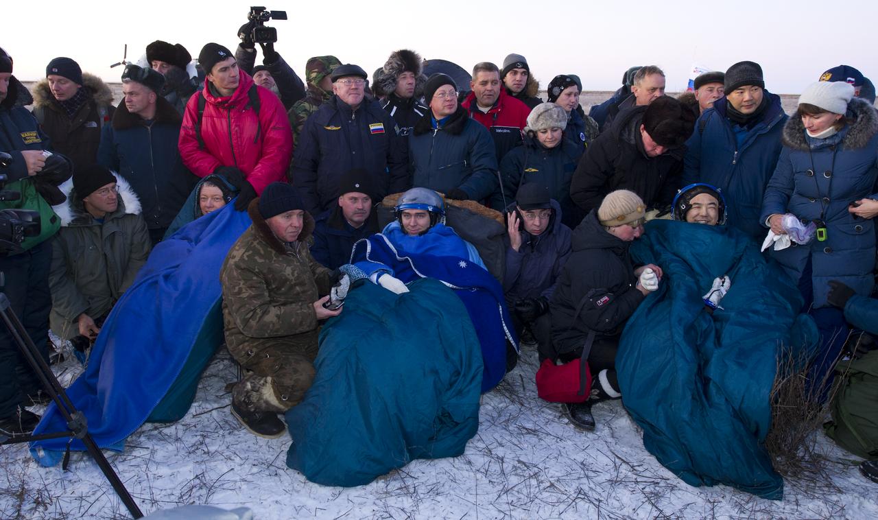 Expedition 29 Commander Mike Fossum, left, Flight Engineers Sergei Volkov, center, and Satoshi Furukawa, sit in chairs outside the Soyuz TMA-02M Capsule just minutes after they landed in a remote area outside the town of Arkalyk, Kazakhstan, on Tuesday, Nov. 22, 2011. NASA Astronaut Fossum, Russian Cosmonaut Volkov and JAXA (Japan Aerospace Exploration Agency) Astronaut Furukawa are returning from more than five months onboard the International Space Station where they served as members of the Expedition 28 and 29 crews. Photo Credit: (NASA/Bill Ingalls)
