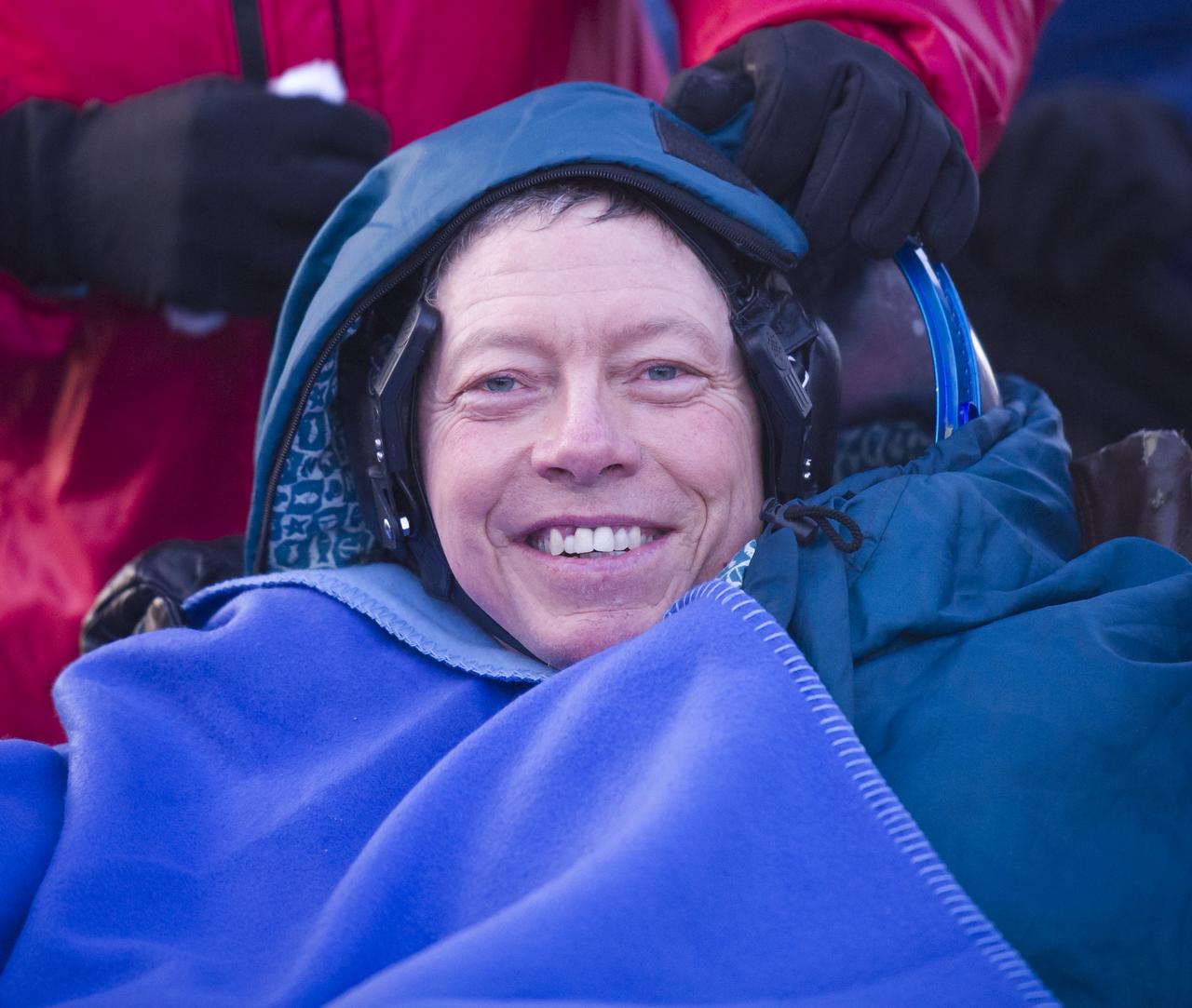 Expedition 29 Commander Mike Fossum smiles as he rest outside the Soyuz TMA-02M Capsule just minutes after he and Expedition 29 Flight Engineers Sergei Volkov and Satoshi Furukawa landed in a remote area outside of the town of Arkalyk, Kazakhstan, on Tuesday, Nov. 22, 2011. NASA Astronaut Fossum, Russian Cosmonaut Volkov and JAXA (Japan Aerospace Exploration Agency) Astronaut Furukawa are returning from more than five months onboard the International Space Station where they served as members of the Expedition 28 and 29 crews. Photo Credit: (NASA/Bill Ingalls)