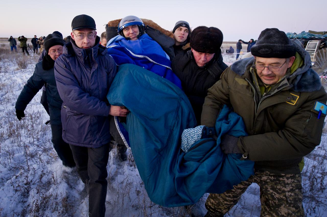 Expedition 29 Flight Engineer Sergei Volkov smiles as he is carried in a chair to the medical tent just minutes after he and Expedition 29 Commander Mike Fossum and Flight Engineer, JAXA (Japan Aerospace Exploration Agency) Astronaut, Satoshi Furukawa landed in a remote area outside of the town of Arkalyk, Kazakhstan, on Tuesday, Nov. 22, 2011. NASA Astronaut Fossum, Russian Cosmonaut Volkov and JAXA (Japan Aerospace Exploration Agency) Astronaut Furukawa are returning from more than five months onboard the International Space Station where they served as members of the Expedition 28 and 29 crews. Photo Credit: (NASA/Bill Ingalls)
