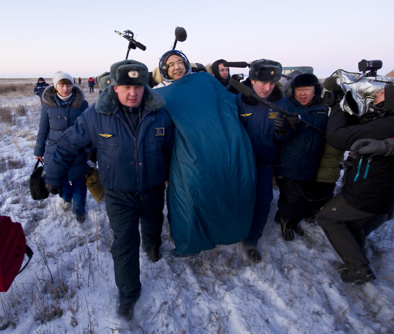 Expedition 29 Flight Engineer, JAXA (Japan Aerospace Exploration Agency) Astronaut, Satoshi Furukawa smiles as he is carried in a chair to the medical tent just minutes after he and Expedition 29 Commander Mike Fossum and Flight Engineer Sergei Volkov landed in a remote area outside of the town of Arkalyk, Kazakhstan, on Tuesday, Nov. 22, 2011. NASA Astronaut Fossum, Russian Cosmonaut Volkov and JAXA (Japan Aerospace Exploration Agency) Astronaut Furukawa are returning from more than five months onboard the International Space Station where they served as members of the Expedition 28 and 29 crews. Photo Credit: (NASA/Bill Ingalls)