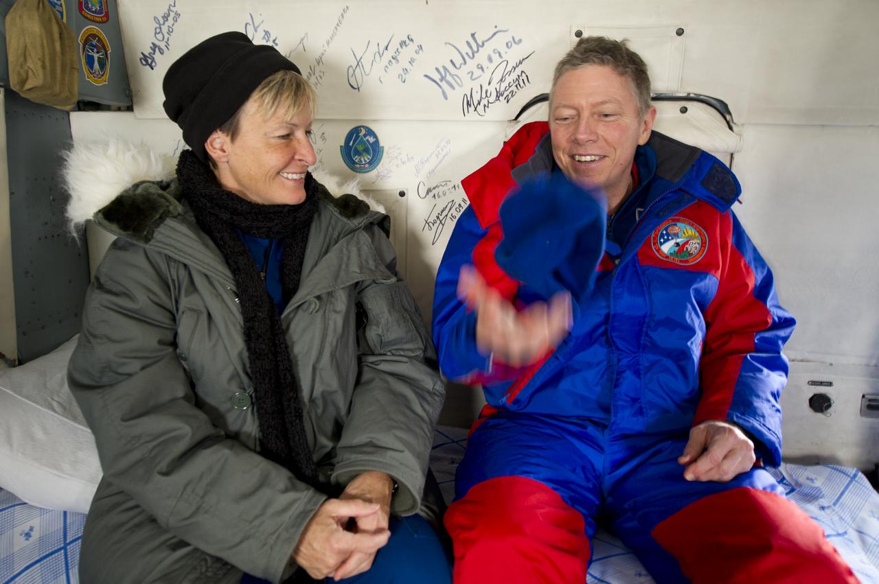 Expedition 29 Commander Mike Fossum, right, tosses his hat into the air and comments to Peggy Whitson, NASA Chief of the Astronaut Office, about how strange the effects of gravity feel as they land in a helicopter in Kustanay, Kazakhstan just a few hours after he and Expedition 29 Flight Engineers Sergei Volkov and Satoshi Furukawa landed in their Soyuz TMA-02M capsule in a remote area outside of the town of Arkalyk, Kazakhstan, on Tuesday, Nov. 22, 2011. NASA Astronaut Fossum, Russian Cosmonaut Volkov and JAXA (Japan Aerospace Exploration Agency) Astronaut Furukawa are returning from more than five months onboard the International Space Station where they served as members of the Expedition 28 and 29 crews. Photo Credit: (NASA/Bill Ingalls)