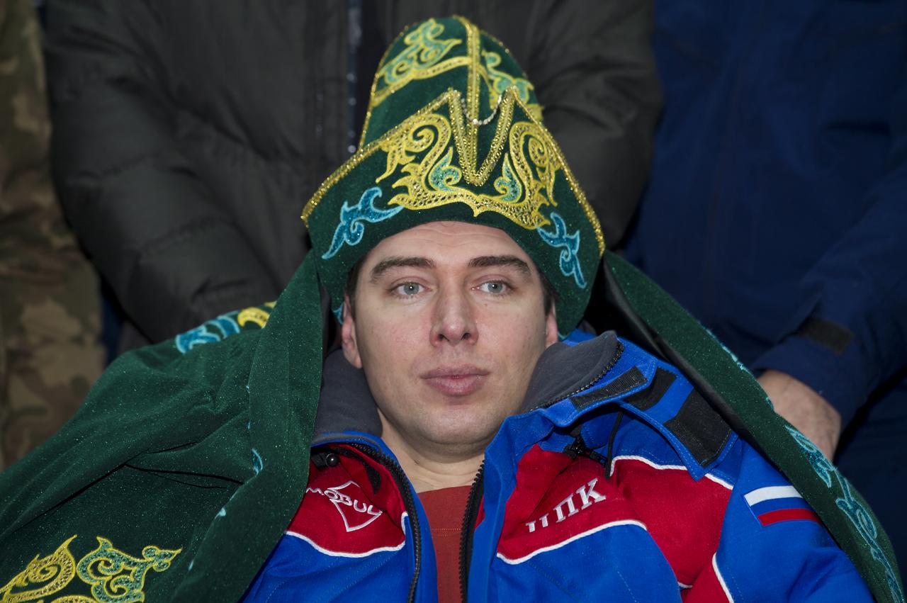 Expedition 29 Flight Engineer Sergei Volkov is seen in a gift of traditional Kazakhstan dress during a welcome ceremony at the Kustanay Airport in Kazakhstan on Tuesday, Nov. 22, 2011. NASA Astronaut Mike Fossum, Russian Cosmonaut Volkov and JAXA (Japan Aerospace Exploration Agency) Astronaut Satoshi Furukawa returned from more than five months onboard the International Space Station where they served as members of the Expedition 28 and 29 crews. Photo Credit: (NASA/Bill Ingalls)