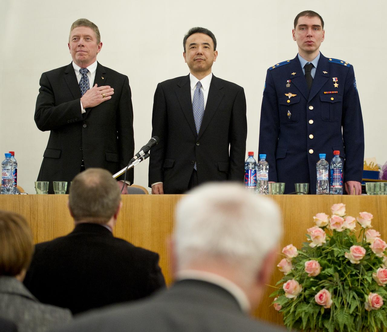 Expedition 29 Commander Mike Fossum, left, Japanese Aerospace Exploration Agency astronaut Satoshi Furukawa, Russian cosmonaut Sergei Volkov, right, are seen during the playing of the national anthem of the United States of America at a traditional welcome home ceremony at the Gagarin Cosmonaut Training Center in Star City, Russia, Thursday, Dec. 15, 2011.  The crew landed on the steppes of Kazakhstan on November 22nd after spending five months living and working aboard the International Space Station.  Photo Credit:  (NASA/Carla Cioffi)