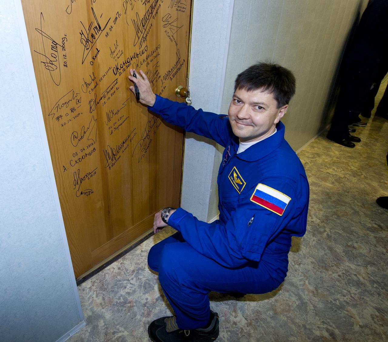Expedition 30 Soyuz Commander Oleg Kononenko is seen after performing the traditional door signing Wednesday, Dec. 21, 2011 at the Cosmonaut Hotel in Baikonur, Kazakhstan. Kononenko was launched onboard the Soyuz rocket the same evening with Expedition 30 NASA Flight Engineer Don Pettit and ESA (European Space Agency) astronaut Andre Kuipers on a mission to the International Space Station (ISS). Photo Credit: (NASA/Carla Cioffi)