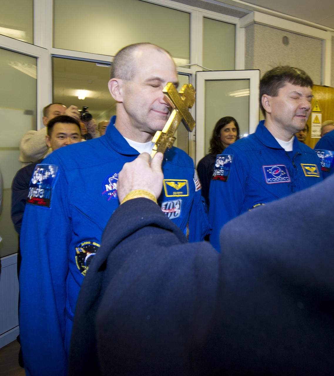 Expedition 30 NASA Flight Engineer Don Pettit, left, receives the traditional blessing from a Russian Orthodox priest at the Cosmonaut Hotel on the day before his Soyuz launch to the International Space Station, Wednesday, Dec. 21, 2011 in Baikonur, Kazakhstan.  Photo Credit: (NASA/Carla Cioffi)