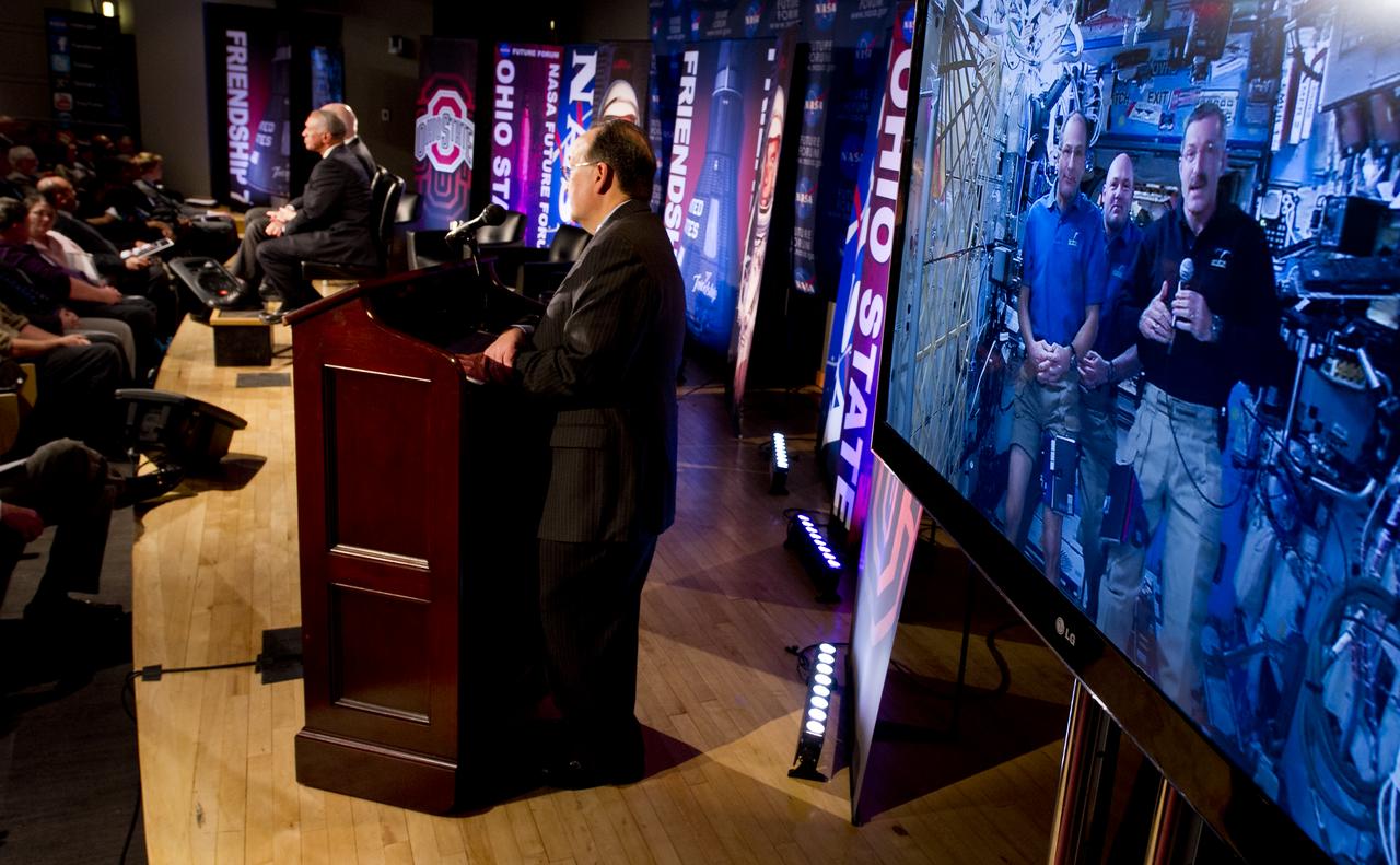 NASA Administrator Charles Bolden surprises Sen. John Glenn, both seated on stage, with a live downlink from International Space Station Expedition 30 crew members Don Pettit, left on screen, Andre Kuipers, and Dan Burbank, right on screen, while Director of the NASA Glenn Research Center Ray Lugo moderates, during NASA's Future Forum at The Ohio State University on Monday, Feb. 20, 2012, in Columbus, Ohio.  Monday marked the 50th anniversary of Glenn's historic flight as the first American to orbit Earth.  Photo Credit: (NASA/Bill Ingalls)
