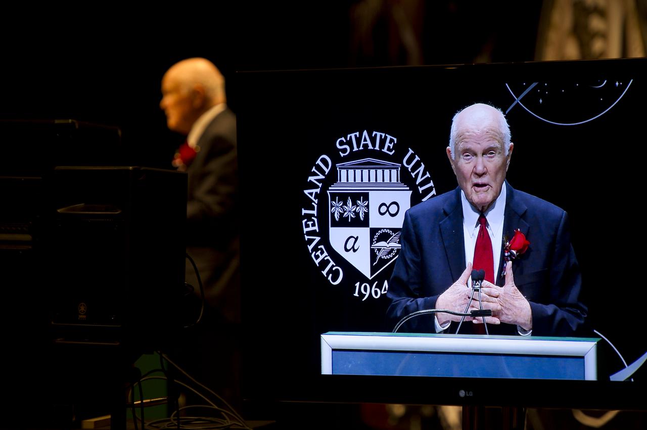 Sen. John Glenn is seen on a monitor as he gives remarks at an event celebrating his legacy and 50 years of americans in orbit held at the Cleveland State University Wolstein Center on Friday, March 3, 2012 in Cleveland, Ohio. Glenn became the first American to orbit Earth in 1962.  Photo Credit: (NASA/Bill Ingalls)