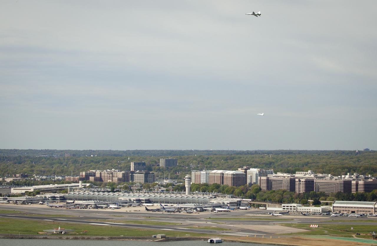 Two NASA T-38 training jets are seen as they fly over Reagan National Airport, Thursday, April 5, 2012 in Arlington, VA.  NASA, in cooperation with the Federal Aviation Administration, conducted training and photographic flights over the DC metropolitan area.  T-38 aircraft have been used for astronaut training for more than 30 years as they allow pilots and mission specialists to think quickly in changing situations, mental experiences the astronauts say are critical to practicing for the rigors of spaceflight.  Photo Credit:  (NASA/Bill Ingalls)
