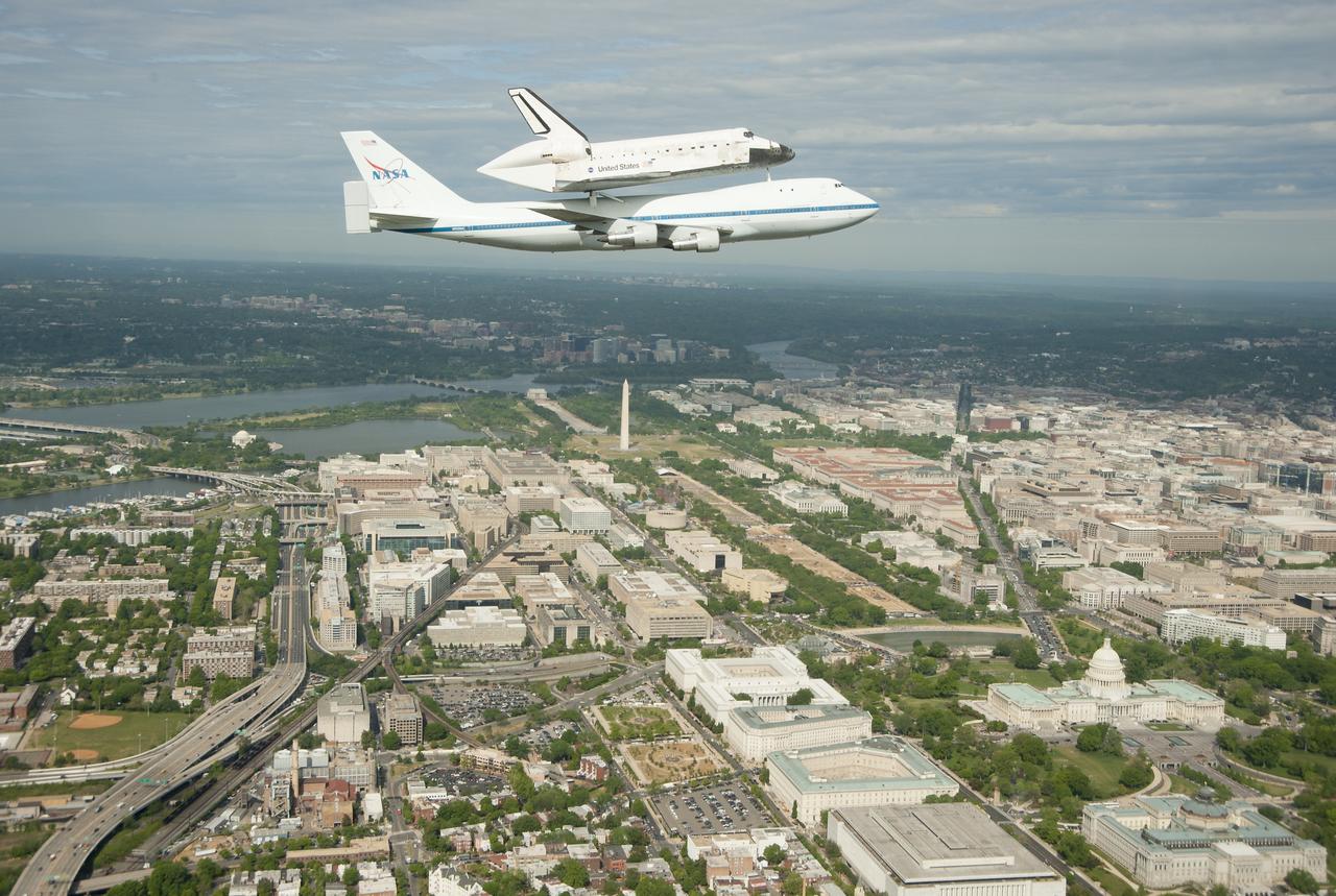 Space shuttle Discovery, mounted atop a NASA 747 Shuttle Carrier Aircraft (SCA), flies over the Washington skyline as seen from a NASA T-38 aircraft, Tuesday, April 17, 2012. Discovery, the first orbiter retired from NASA’s shuttle fleet, completed 39 missions, spent 365 days in space, orbited the Earth 5,830 times, and traveled 148,221,675 miles. NASA will transfer Discovery to the National Air and Space Museum to begin its new mission to commemorate past achievements in space and to educate and inspire future generations of explorers. Photo Credit: (NASA/Robert Markowitz)