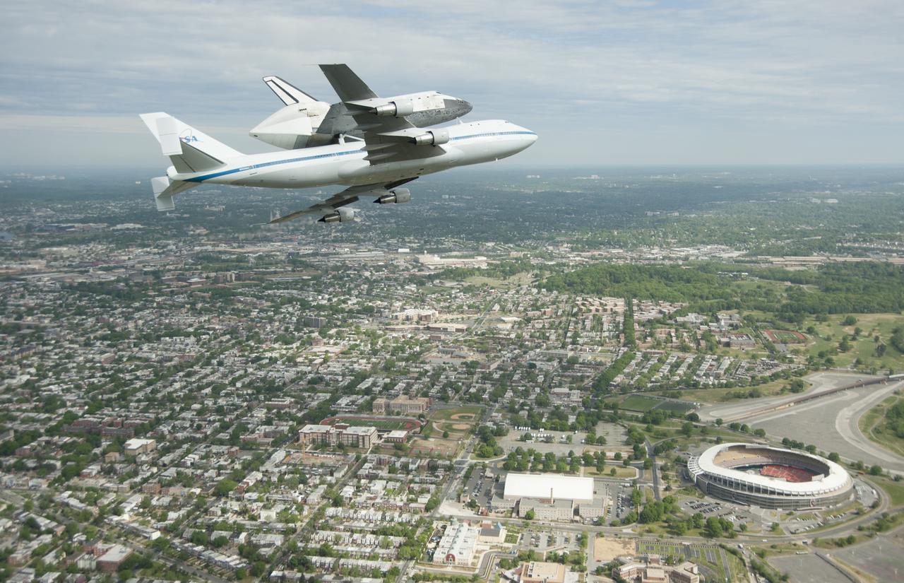 Space shuttle Discovery, mounted atop a NASA 747 Shuttle Carrier Aircraft (SCA), flies over the Washington skyline as seen from a NASA T-38 aircraft, Tuesday, April 17, 2012. Discovery, the first orbiter retired from NASA’s shuttle fleet, completed 39 missions, spent 365 days in space, orbited the Earth 5,830 times, and traveled 148,221,675 miles. NASA will transfer Discovery to the National Air and Space Museum to begin its new mission to commemorate past achievements in space and to educate and inspire future generations of explorers. Photo Credit: (NASA/Robert Markowitz)