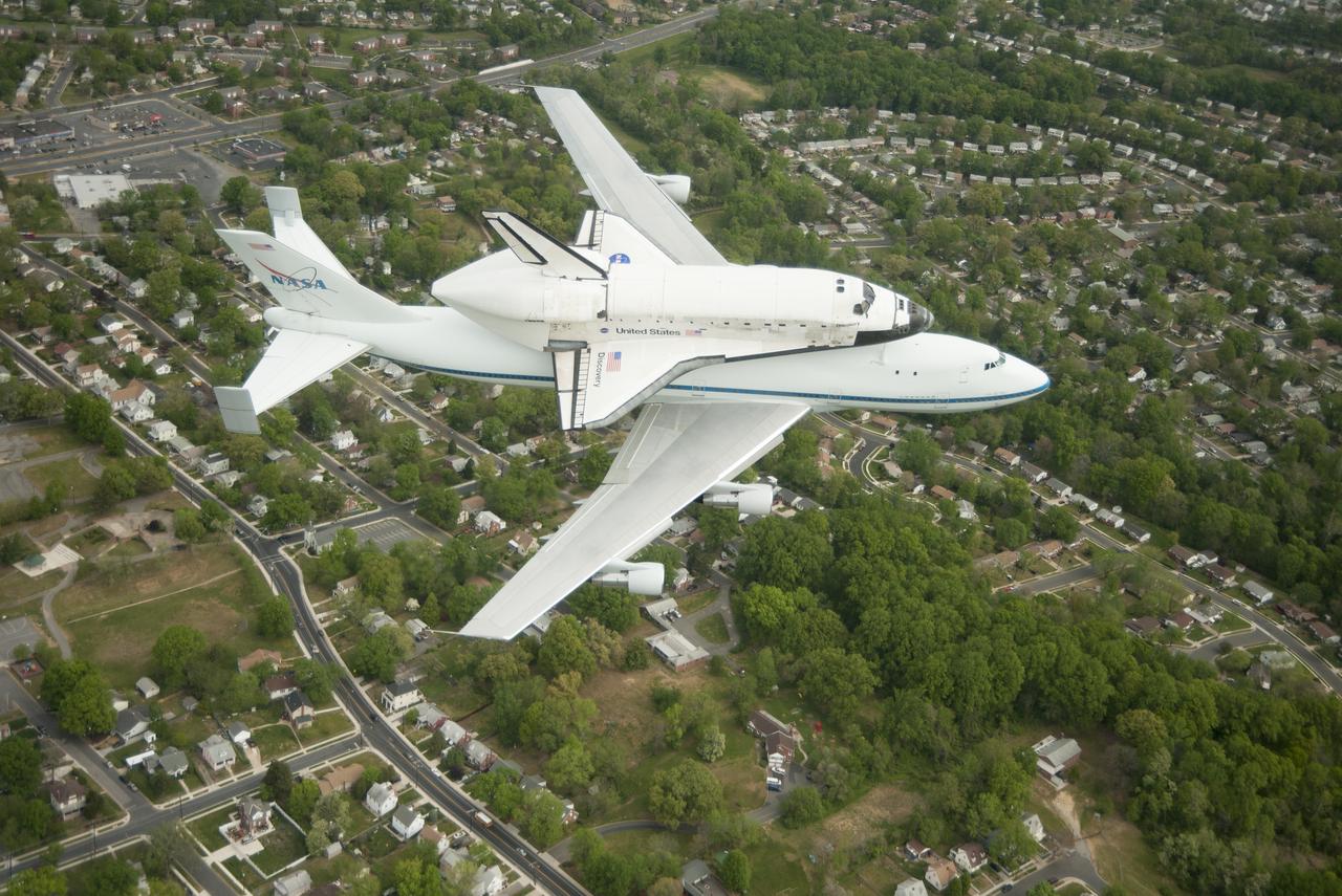 Space shuttle Discovery, mounted atop a NASA 747 Shuttle Carrier Aircraft (SCA), flies over the Washington skyline as seen from a NASA T-38 aircraft, Tuesday, April 17, 2012. Discovery, the first orbiter retired from NASA’s shuttle fleet, completed 39 missions, spent 365 days in space, orbited the Earth 5,830 times, and traveled 148,221,675 miles. NASA will transfer Discovery to the National Air and Space Museum to begin its new mission to commemorate past achievements in space and to educate and inspire future generations of explorers. Photo Credit: (NASA/Robert Markowitz)