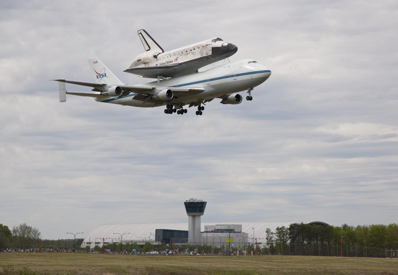 Space shuttle Discovery, mounted atop a NASA 747 Shuttle Carrier Aircraft (SCA) flies over the Steven F. Udvar-Hazy Center, Tuesday, April 17, 2012, in Washington. Discovery, the first orbiter retired from NASA’s shuttle fleet, completed 39 missions, spent 365 days in space, orbited the Earth 5,830 times, and traveled 148,221,675 miles. NASA will transfer Discovery to the National Air and Space Museum to begin its new mission to commemorate past achievements in space and to educate and inspire future generations of explorers. Photo Credit: (NASA/Smithsonian Institution/Dane Penland)