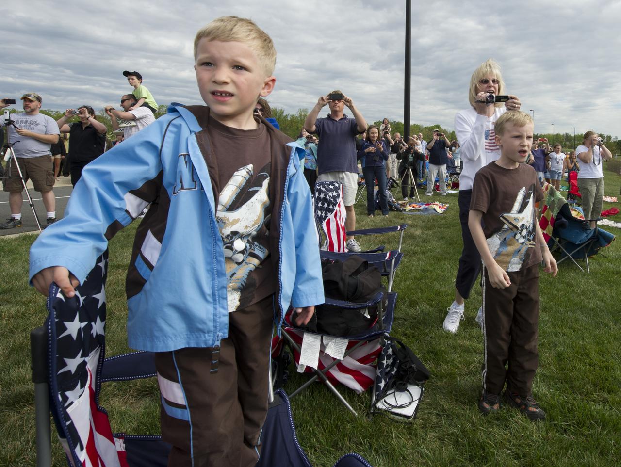 Jarod Ondas (left), of Virginia, and his brother Austin, watch as space shuttle Discovery approaches the National Air and Space Museum’s Steven F. Udvar-Hazy Center for its fly-over, Tuesday, April 17, 2012, in Chantilly, Va.  Discovery, the first orbiter retired from NASA’s shuttle fleet, completed 39 missions, spent 365 days in space, orbited the Earth 5,830 times, and traveled 148,221,675 miles.  NASA will transfer Discovery to the National Air and Space Museum to begin its new mission to commemorate past achievements in space and to educate and inspire future generations of explorers.  Photo Credit: (NASA/Carla Cioffi)