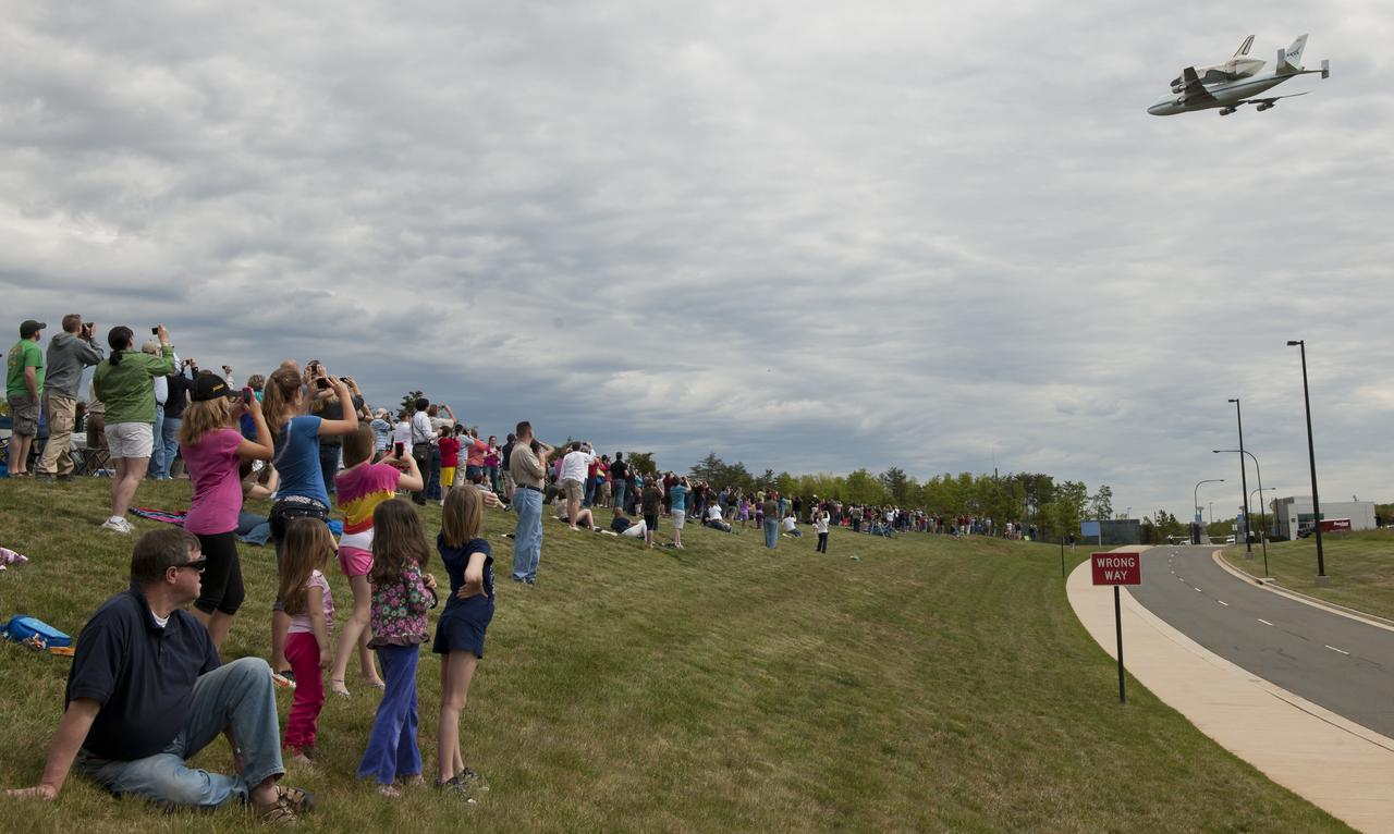 Spectators watch as space shuttle Discovery, mounted atop a NASA 747 Shuttle Carrier Aircraft (SCA) flies over the National Air and Space Museum’s Steven F. Udvar-Hazy Center, Tuesday, April 17, 2012, in Chantilly, Va. Discovery, the first orbiter retired from NASA’s shuttle fleet, completed 39 missions, spent 365 days in space, orbited the Earth 5,830 times, and traveled 148,221,675 miles. NASA will transfer Discovery to the National Air and Space Museum to begin its new mission to commemorate past achievements in space and to educate and inspire future generations of explorers. Photo Credit: (NASA/Carla Cioffi)