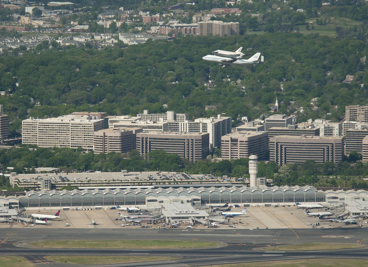 Space shuttle Discovery, mounted atop a NASA 747 Shuttle Carrier Aircraft (SCA) makes its way past Ronald Reagan Washington National Airport, Tuesday, April 17, 2012, in Arlington, Va. Discovery, the first orbiter retired from NASA’s shuttle fleet, completed 39 missions, spent 365 days in space, orbited the Earth 5,830 times, and traveled 148,221,675 miles. NASA will transfer Discovery to the National Air and Space Museum to begin its new mission to commemorate past achievements in space and to educate and inspire future generations of explorers. Photo Credit: (NASA/Bill Ingalls)