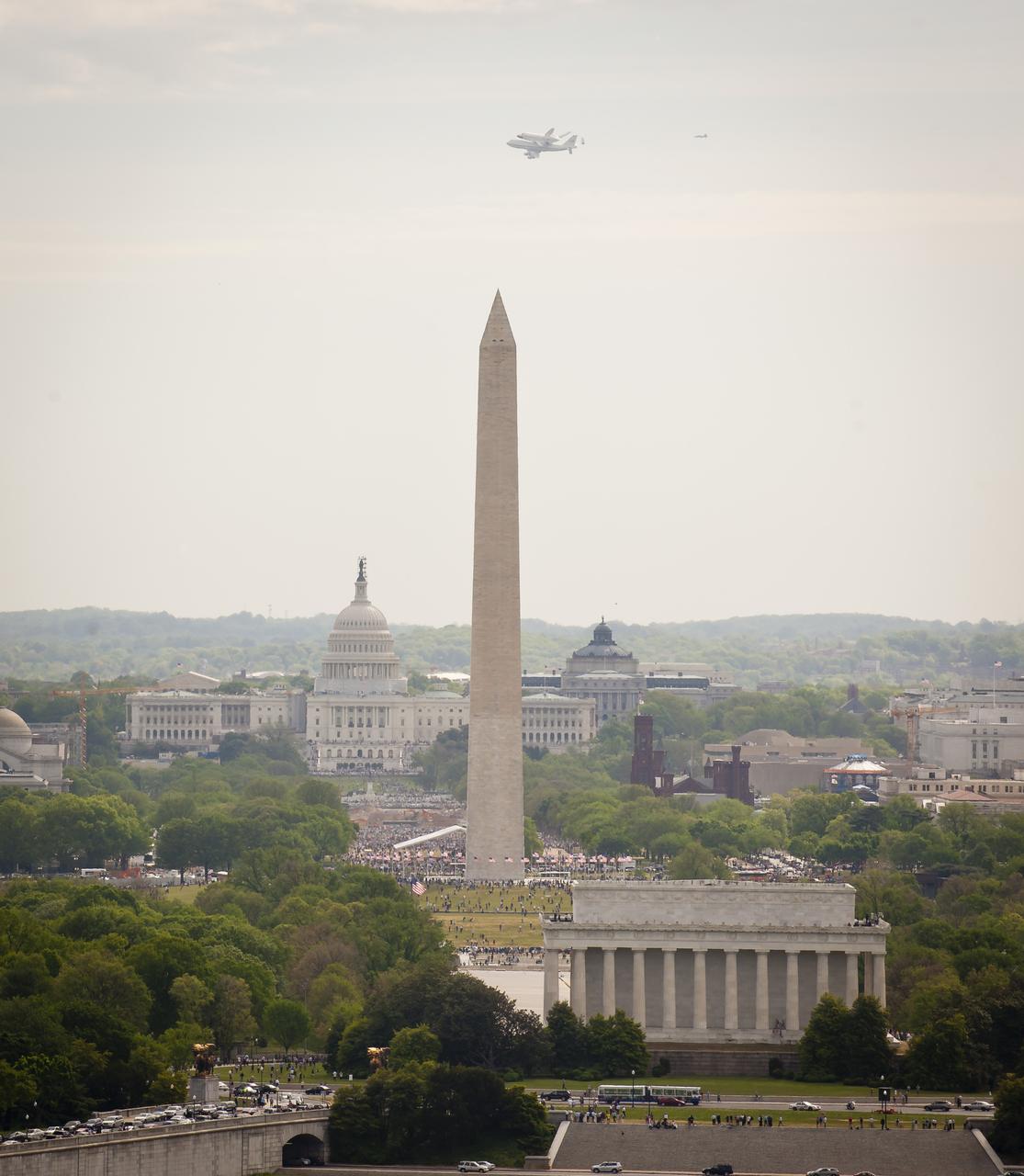 Space shuttle Discovery, mounted atop a NASA 747 Shuttle Carrier Aircraft (SCA) is seen from Top of the Town in Arlington, Virginia as it flies near the U.S. Capitol, Tuesday, April 17, 2012, in Washington. Discovery, the first orbiter retired from NASA’s shuttle fleet, completed 39 missions, spent 365 days in space, orbited the Earth 5,830 times, and traveled 148,221,675 miles. NASA will transfer Discovery to the National Air and Space Museum to begin its new mission to commemorate past achievements in space and to educate and inspire future generations of explorers. Photo Credit: (NASA/Chris Gunn)