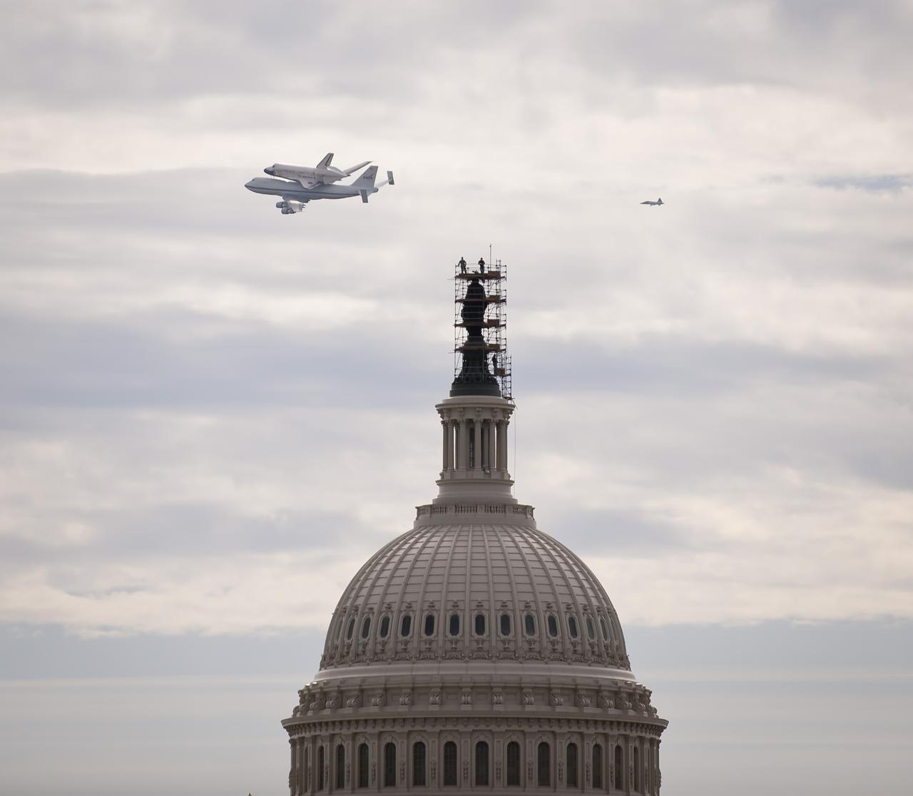 Space shuttle Discovery, mounted atop a NASA 747 Shuttle Carrier Aircraft (SCA) is seen as it flies near the U.S. Capitol, Tuesday, April 17, 2012, in Washington. Discovery, the first orbiter retired from NASA’s shuttle fleet, completed 39 missions, spent 365 days in space, orbited the Earth 5,830 times, and traveled 148,221,675 miles. NASA will transfer Discovery to the National Air and Space Museum to begin its new mission to commemorate past achievements in space and to educate and inspire future generations of explorers. Photo Credit: (NASA/Smithsonian Institution/Harold Dorwin)