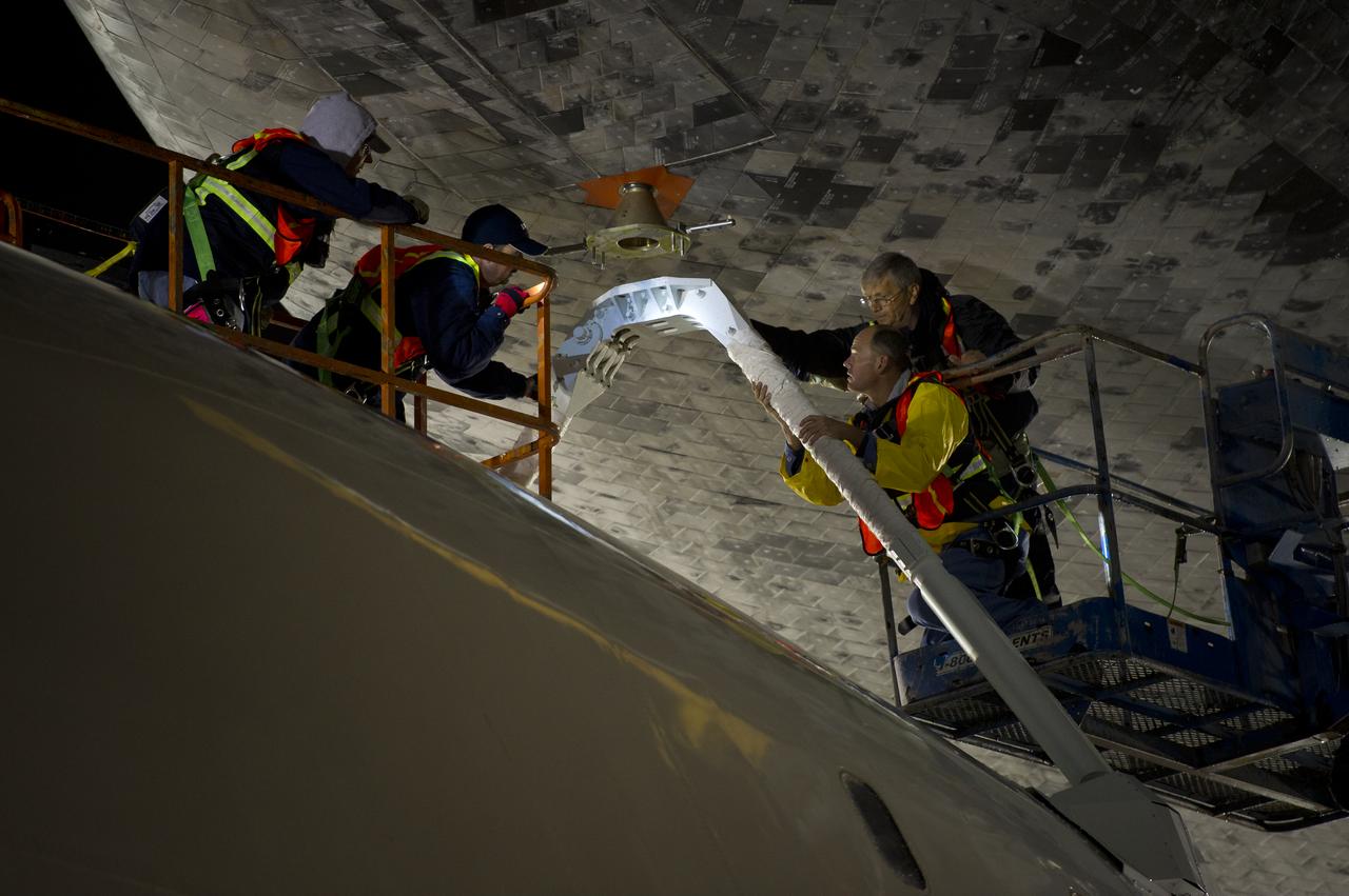 Workers monitor the lift of the space shuttle Discovery from the top of the NASA 747 Shuttle Carrier Aircraft (SCA) at Washington Dulles International Airport, Thursday, April 19, 2012, in Sterling, VA.  Discovery, the first orbiter retired from NASA’s shuttle fleet, completed 39 missions, spent 365 days in space, orbited the Earth 5,830 times, and traveled 148,221,675 miles. NASA will transfer Discovery to the National Air and Space Museum to begin its new mission to commemorate past achievements in space and to educate and inspire future generations of explorers. Photo Credit: (NASA/Bill Ingalls)
