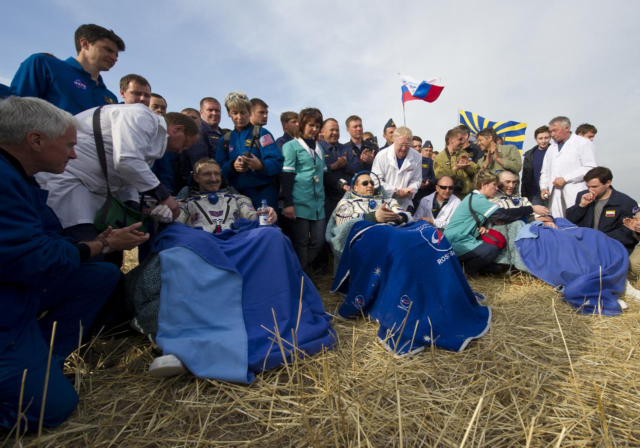 Expedition 30 Commander Dan Burbank, left, Flight Engineers Anton Shkaplerov, center, and Anatoly Ivanishin sit in chairs outside the Soyuz Capsule just minutes after they landed in a remote area outside the town of Arkalyk, Kazakhstan, on Friday, April 27, 2012. NASA Astronaut Burbank, Russian Cosmonauts Shkaplerov and Ivanishin are returning from more than five months onboard the International Space Station where they served as members of the Expedition 29 and 30 crews. Photo Credit: (NASA/Carla Cioffi)