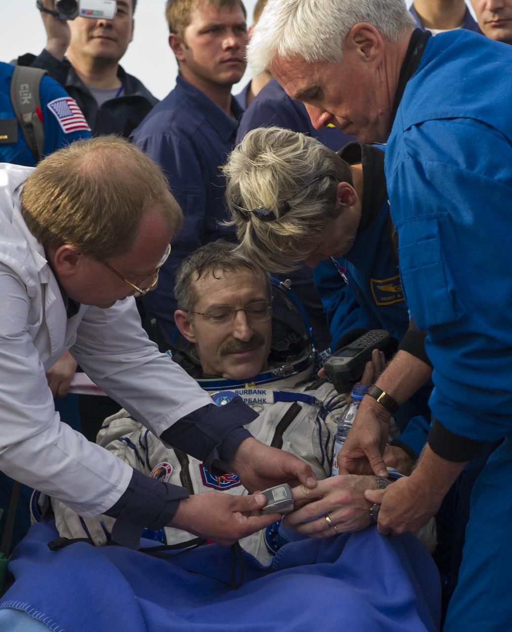 Expedition 30 Commander Dan Burbank, center, is attended to by his doctor and crew support personnel following his landing in the Soyuz-22 spacecraft, Friday, April 27, 2012. NASA Astronaut Burbank, Russian Cosmonauts Shkaplerov and Ivanishin are returning from more than five months onboard the International Space Station where they served as members of the Expedition 29 and 30 crews.  Photo Credit: (NASA/Carla Cioffi)