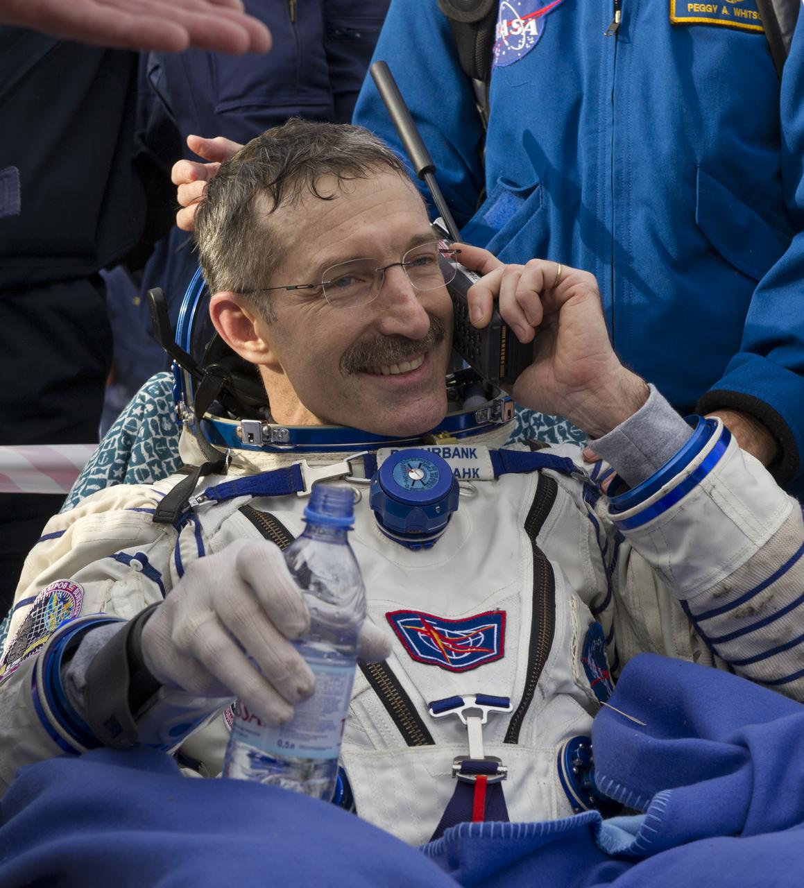 Expedition 30 Commander Dan Burbank speaks with his family via satellite phone outside the Soyuz TMA-22 capsule just minutes after he and Expedition 30 Flight Engineers Anton Shkaplerov and Anatoly Ivanishin landed in a remote area outside of the town of Arkalyk, Kazakhstan, on Friday, April 27, 2012. NASA Astronaut Burbank, Russian Cosmonauts Shkaplerov and Ivanishin are returning from more than five months onboard the International Space Station where they served as members of the Expedition 29 and 30 crews. Photo Credit: (NASA/Carla Cioffi)