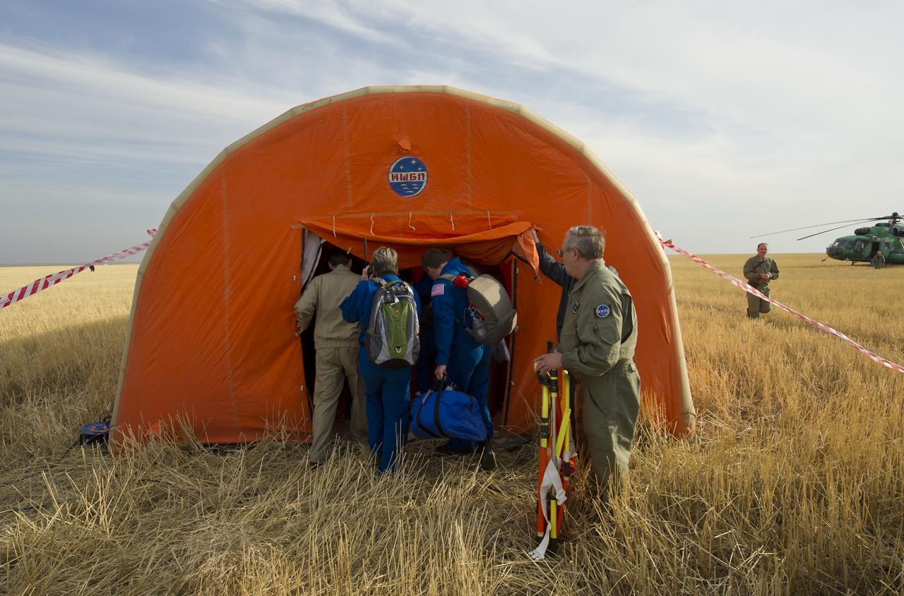 NASA and GCTC (Gagarin Cosmonaut Training Center) crew support personnel enter the inflatable medical tent in which Expedition 30 Commander Dan Burbank, and flight engineers Anton Shkaplerov and Anatoly Ivanishin are being checked out shortly after their Soyuz TMA-22 capsule landed out side the town of Arkalyk, Kazakhstan, Friday, April 27, 2012. Burbank, and Russian Cosmonauts Shkaplerov and Ivanishin are returning from more than five months onboard the International Space Station where they served as members of the Expedition 29 and 30 crews. Photo Credit: (NASA/Carla Cioffi)