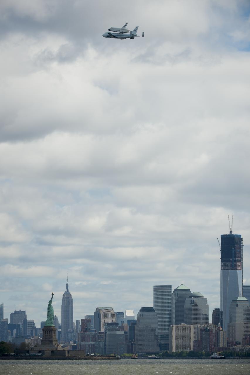 Space shuttle Enterprise, mounted atop a NASA 747 Shuttle Carrier Aircraft (SCA), is seen as it flies near the Statue of Liberty, Friday, April 27, 2012, in New York. Enterprise was the first shuttle orbiter built for NASA performing test flights in the atmosphere and was incapable of spaceflight. Originally housed at the Smithsonian's Steven F. Udvar-Hazy Center, Enterprise will be demated from the SCA and placed on a barge that will eventually be moved by tugboat up the Hudson River to the Intrepid Sea, Air & Space Museum in June. Photo Credit: (NASA/Bill Ingalls)