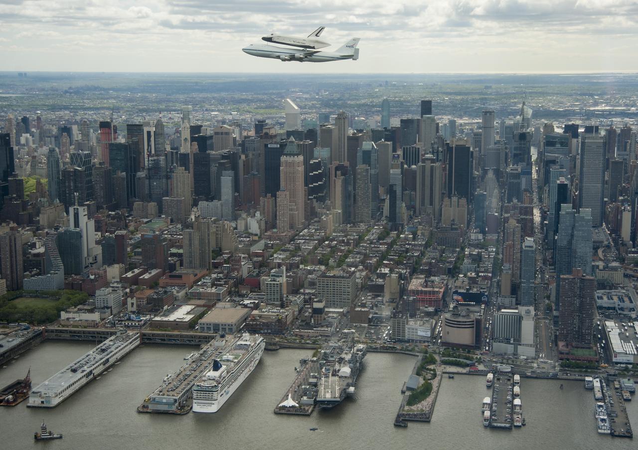 CAPTION: ---------------------------- Space shuttle Enterprise, mounted atop a NASA 747 Shuttle Carrier Aircraft (SCA), is seen as it flies near the Intrepid Sea, Air and Space Museum, Friday, April 27, 2012, in New York. Enterprise was the first shuttle orbiter built for NASA performing test flights in the atmosphere and was incapable of spaceflight. Originally housed at the Smithsonian's Steven F. Udvar-Hazy Center, Enterprise will be demated from the SCA and placed on a barge that will eventually be moved by tugboat up the Hudson River to the Intrepid Sea, Air & Space Museum in June. Photo Credit: (NASA/Robert Markowitz)