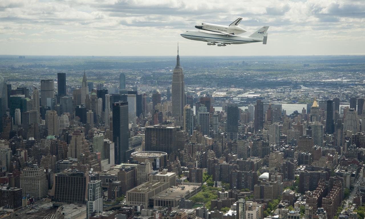 Space shuttle Enterprise, mounted atop a NASA 747 Shuttle Carrier Aircraft (SCA), is seen as it flies near the Empire State Building, Friday, April 27, 2012, in New York. Enterprise was the first shuttle orbiter built for NASA performing test flights in the atmosphere and was incapable of spaceflight. Originally housed at the Smithsonian's Steven F. Udvar-Hazy Center, Enterprise will be demated from the SCA and placed on a barge that will eventually be moved by tugboat up the Hudson River to the Intrepid Sea, Air & Space Museum in June. Photo Credit: (NASA/Robert Markowitz)