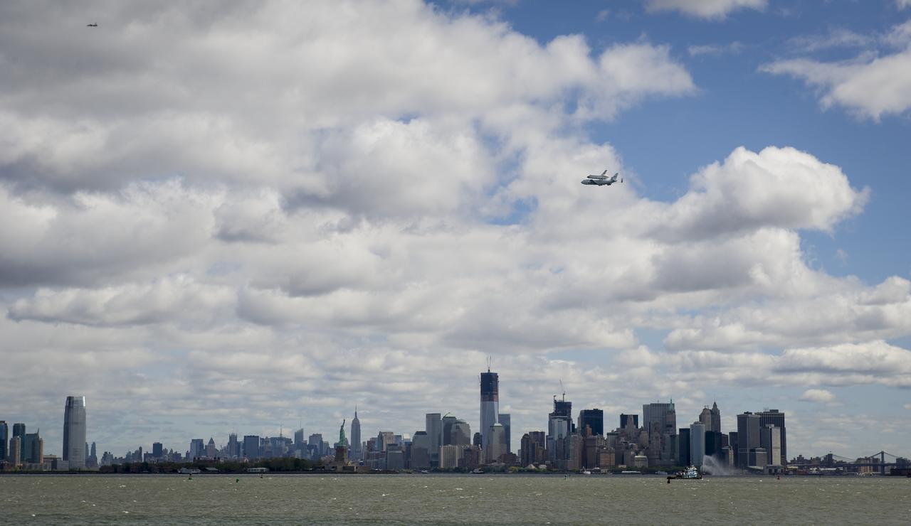 Space shuttle Enterprise, mounted atop a NASA 747 Shuttle Carrier Aircraft (SCA), is seen as it flies over the Hudson River, Friday, April 27, 2012, in New York. Enterprise was the first shuttle orbiter built for NASA performing test flights in the atmosphere and was incapable of spaceflight. Originally housed at the Smithsonian's Steven F. Udvar-Hazy Center, Enterprise will be demated from the SCA and placed on a barge that will eventually be moved by tugboat up the Hudson River to the Intrepid Sea, Air & Space Museum in June. Photo Credit: (NASA/Bill Ingalls)