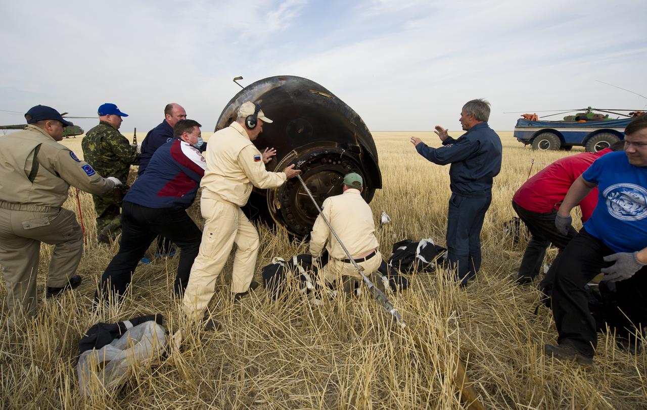 Russian support personnel work to help get crew members out of the Soyuz TMA-22 spacecraft shortly after the capsule landed with Expedition 30 Commander Dan Burbank, and Flight Engineers Anton Skhaplerov and Anatoly Ivanishin in a remote area outside of the town of Arkalyk, Kazakhstan, on Friday, April 27, 2012. NASA Astronaut Burbank, Russian Cosmonauts Shkaplerov and Ivanishin are returning from more than five months onboard the International Space Station where they served as members of the Expedition 29 and 30 crews. Photo Credit: (NASA/Carla Cioffi)