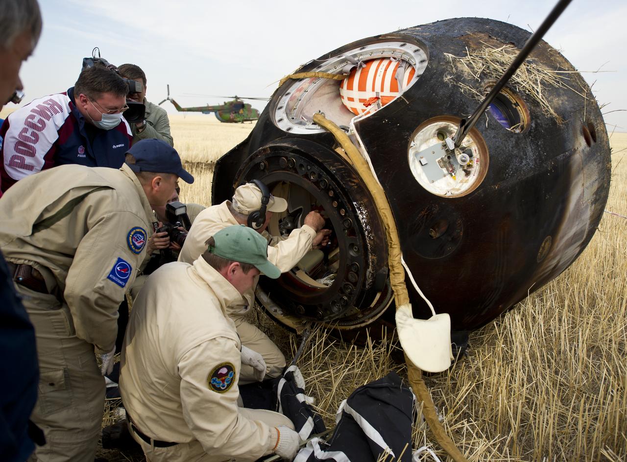 Russian support personnel work to help get crew members out of the Soyuz TMA-22 spacecraft shortly after the capsule landed with Expedition 30 Commander Dan Burbank, and Flight Engineers Anton Skhaplerov and Anatoly Ivanishin in a remote area outside of the town of Arkalyk, Kazakhstan, on Friday, April 27, 2012. NASA Astronaut Burbank, Russian Cosmonauts Shkaplerov and Ivanishin are returning from more than five months onboard the International Space Station where they served as members of the Expedition 29 and 30 crews. Photo Credit: (NASA/Carla Cioffi)