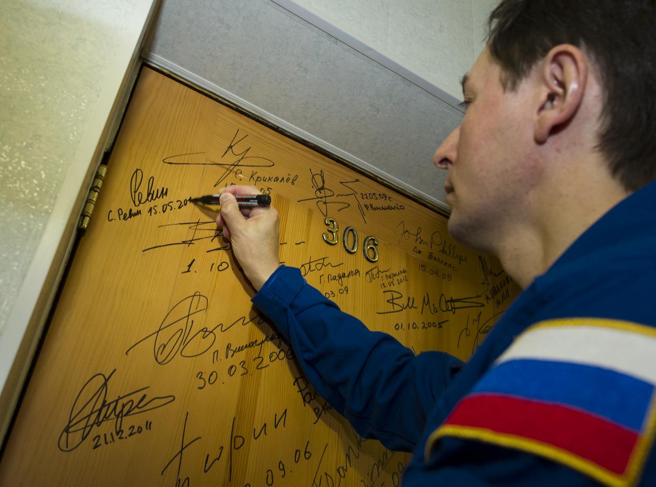 Expedition 31 Flight Engineer Sergei Revin performs the tradition of signing one of the doors at the Cosmonaut Hotel on Tuesday, May 15, 2012 in Baikonur, Kazakhstan. The Soyuz spacecraft with Revin, Expedition 31 Soyuz Commander Gennady Padalka, and NASA Flight Engineer Joe Acaba aboard launched at 9:01 a.m. Kazakhstan time on Tuesday, May 15.  Photo Credit (NASA/Bill Ingalls)