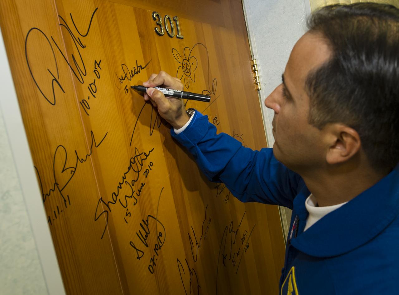 Expedition 31 Flight Engineer Joe Acaba performs the tradition of signing one of the doors at the Cosmonaut Hotel on Tuesday, May 15, 2012 in Baikonur, Kazakhstan. The Soyuz spacecraft with Acaba, Expedition 31 Soyuz Commander Gennady Padalka, and Flight Engineer Sergei Revin of Russia  aboard launched at 9:01 a.m. Kazakhstan time on Tuesday, May 15.  Photo Credit (NASA/Bill Ingalls)