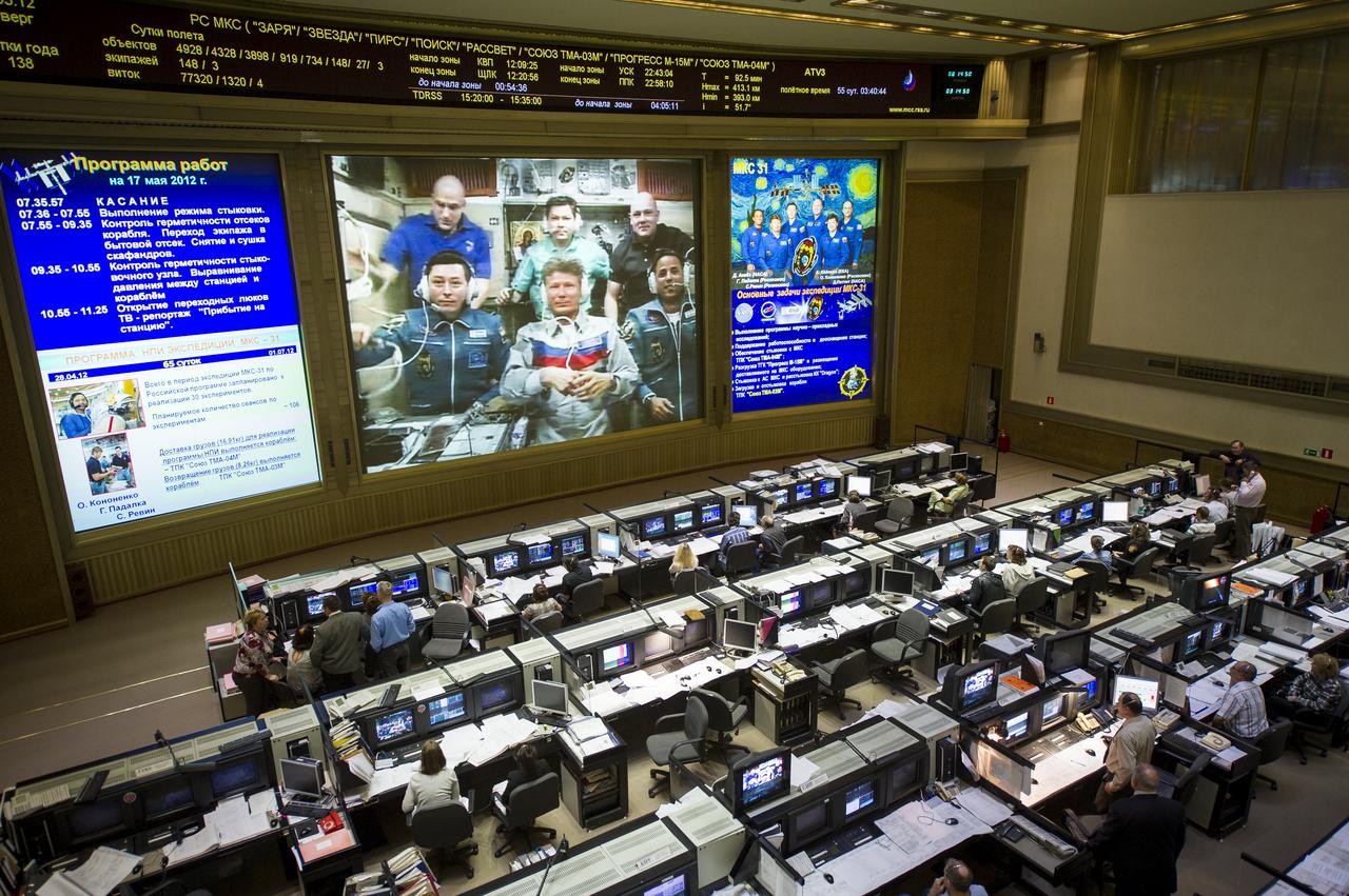 View from the balcony of the Russian Mission Control Center shows live television of the Expedition 31 crew members gathered together on the International Space Station a few hours after the Soyuz TMA-04M spacecraft docked on Thursday, May 17, 2012, in Korolev, Russia. Pictured are Expedition 31 crew members NASA Flight Engineer Don Pettit, back left, Oleg Kononenko of Russia, ESA (European Space Agency) astronaut and Flight Engineer Andre Kuipers, back right, Flight Engineer Sergei Revin, front left, Soyuz Commander Gennady Padalka, and Flight Engineer Joe Acaba, bottom right. Padalka, Revin and Acaba's arrival to the International Space Station comes two days after they launched from the Baikonur Cosmodrome in Kazakhstan.  Photo Credit (NASA/Bill Ingalls)