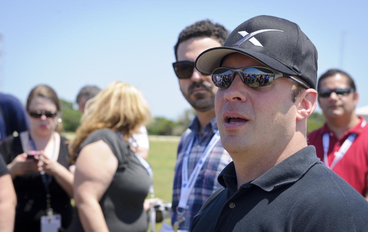 NASA Social participants are reflected in the sunglasses of former NASA astronaut Garrett Reisman, now a senior engineer working on astronaut safety and mission assurance for Space Exploration Technologies, or SpaceX, as he speaks with them, Friday, May 18, 2012, at the launch complex where the company's Falcon 9 rocket is set to launch early Friday morning at Cape Canaveral Air Force Station in Cape Canaveral, Fla. Photo Credit: (NASA/Paul E. Alers)