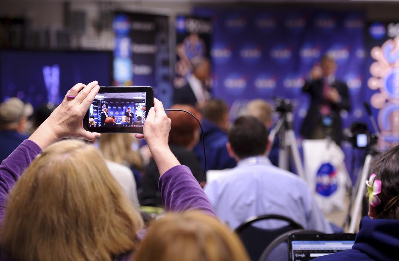 A NASA Social follower holds up a mobile device as NASA Administrator Charles Bolden, left, and Kennedy Space Center director Robert Cabana appear at the NASA Social event, Friday morning, May 19, 2012, at Kennedy Space Center in Cape Canaveral, Fla. About 50 NASA Social followers attended an event as part of activities surrounding the launch of Space Exploration Technologies, or SpaceX, demonstration mission of the company's Falcon 9 rocket to the International Space Station. Photo Credit: (NASA/Paul E. Alers)