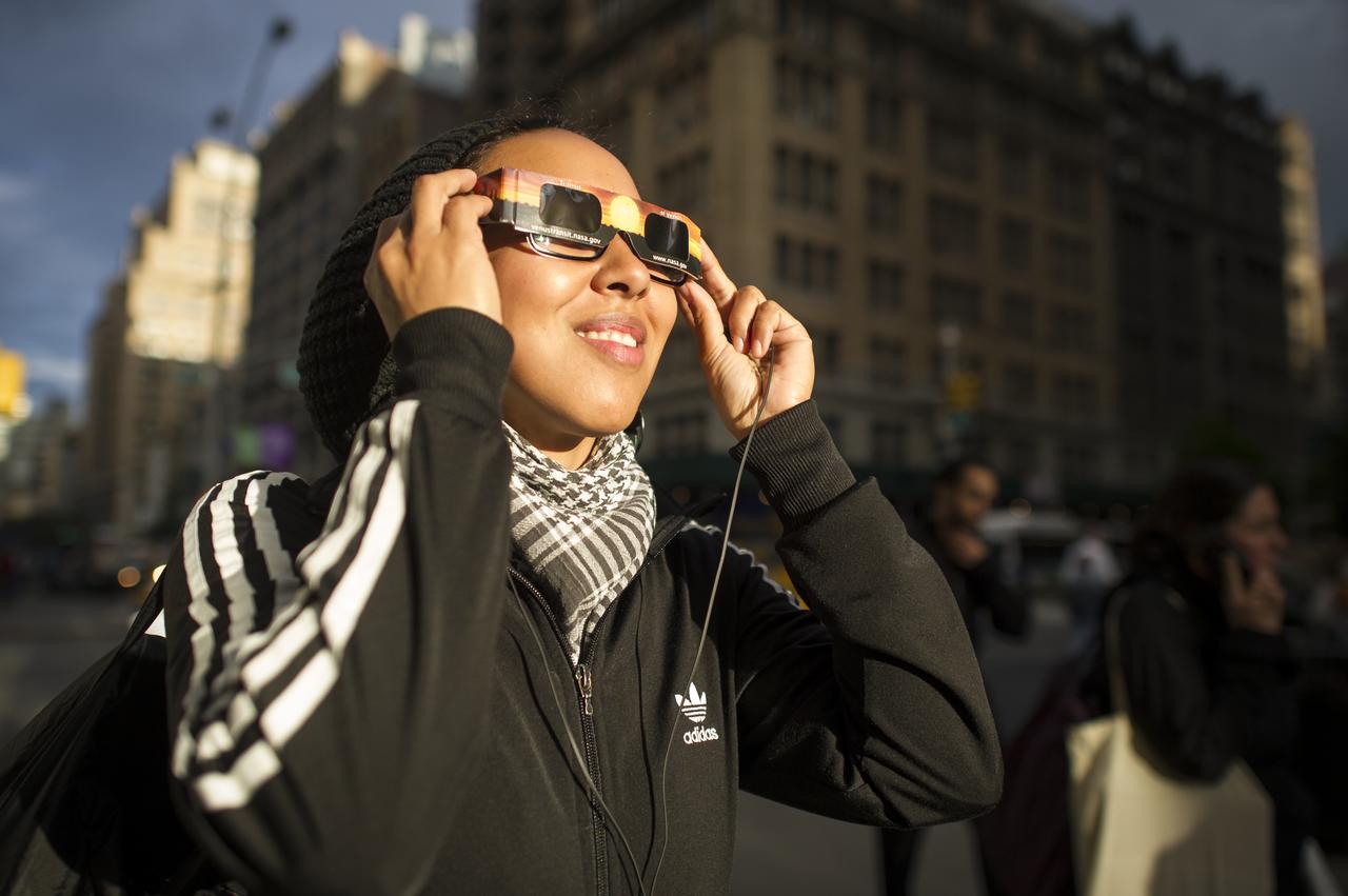 It appeared that New Yorkers were not going to be able to see the transit of the planet Venus across the Sun, but just before the transit was over the sun broke through the clouds and Yvette Lee Kang was able to catch a glimpse of the transit on Tuesday, June 5, 2012 in New York.  A transit of Venus occurs when the planet passes directly between the sun and earth.  This alignment is rare, coming in pairs that are eight years apart but separated by over a century.  The next Venus transit will be in December 2117.  Photo Credit: (NASA/Bill Ingalls)